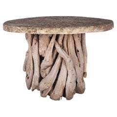 Table en bois flotté en teck avec plateau en pierre calcaire fortement altérée par les intempéries