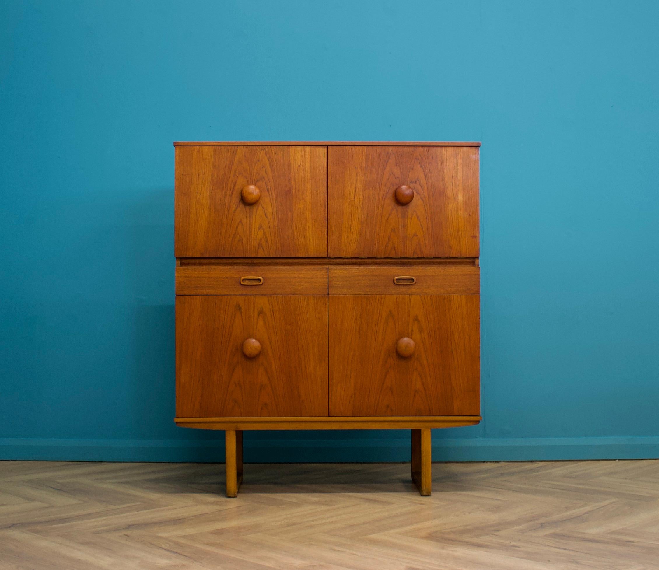 A teak drinks cabinet, circa 1960s

Featuring two drawers, two cupboards and a pull down drinks cupboard

The original light is present, but is not wired in