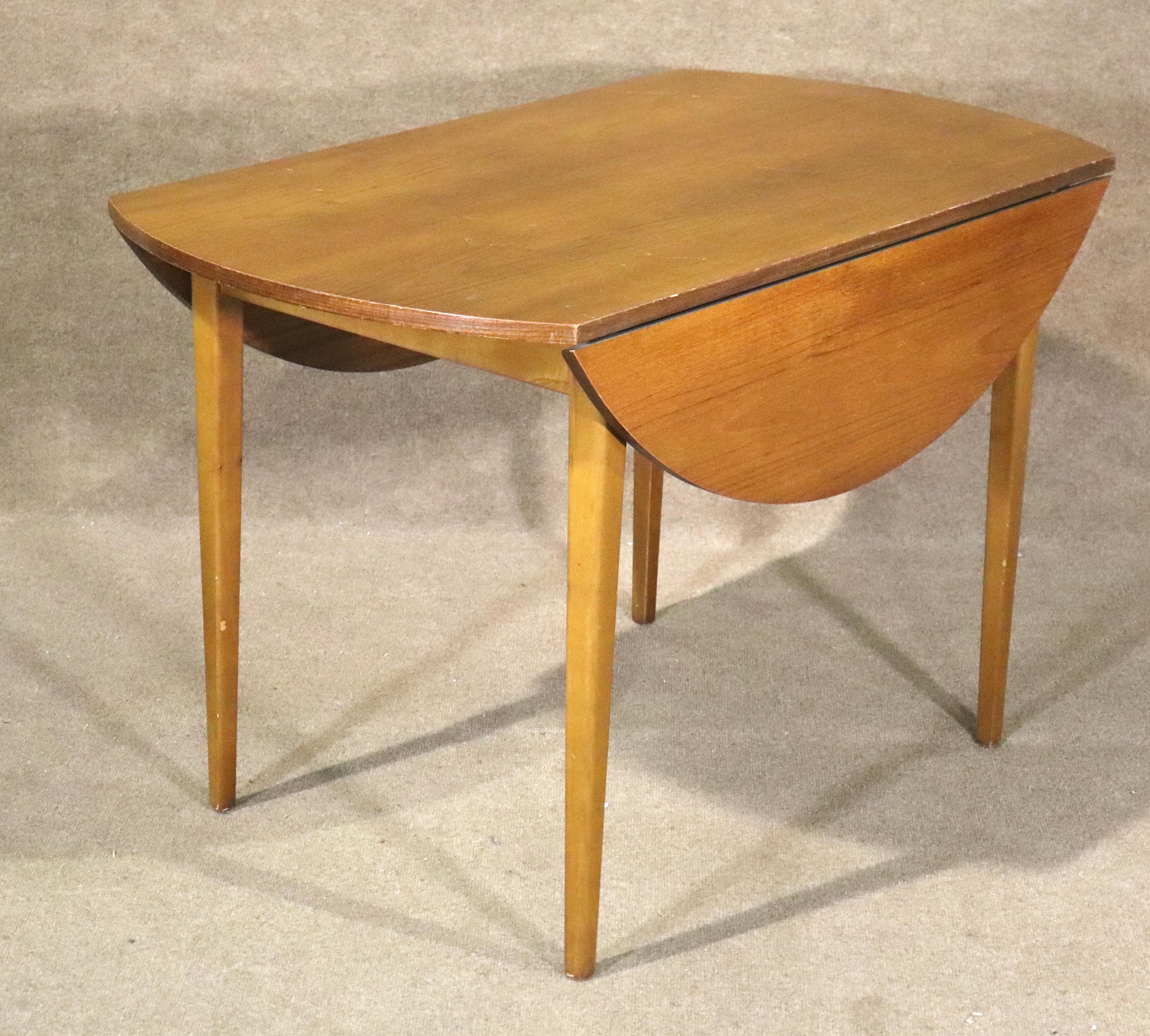 Tavolo da pranzo danese moderno di metà secolo con due ante a ribalta. Venature calde del teak su tutta la superficie con gambe lunghe e sottili.
Si prega di confermare la posizione NY o NJ