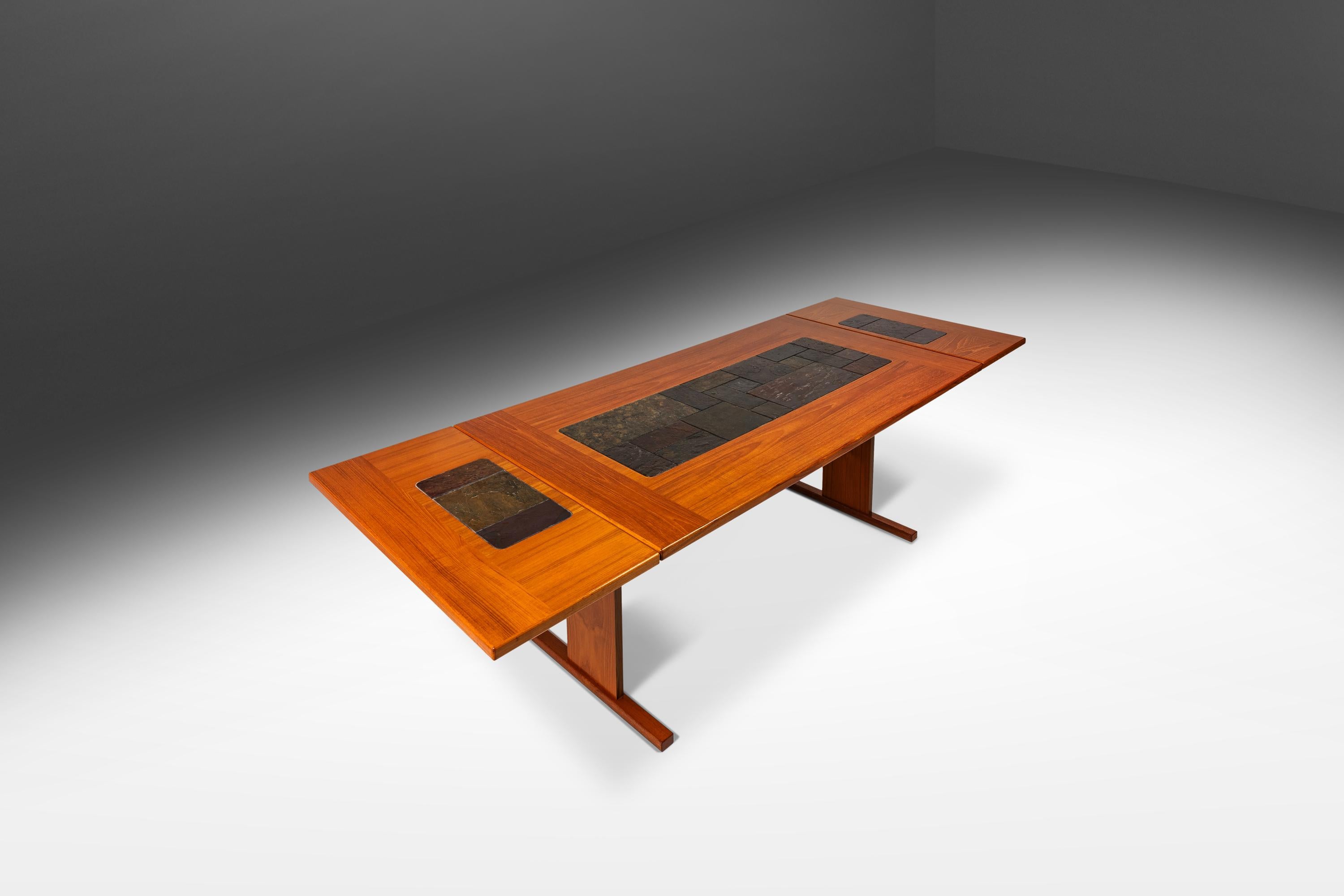 Te presentamos un auténtico tesoro de la modernidad danesa: una excepcional mesa de tablero abatible diseñada por el respetado Poul H. Poulsen. Con un tablero de azulejos de cerámica pintados a mano con intrigantes formas geométricas y un marco de