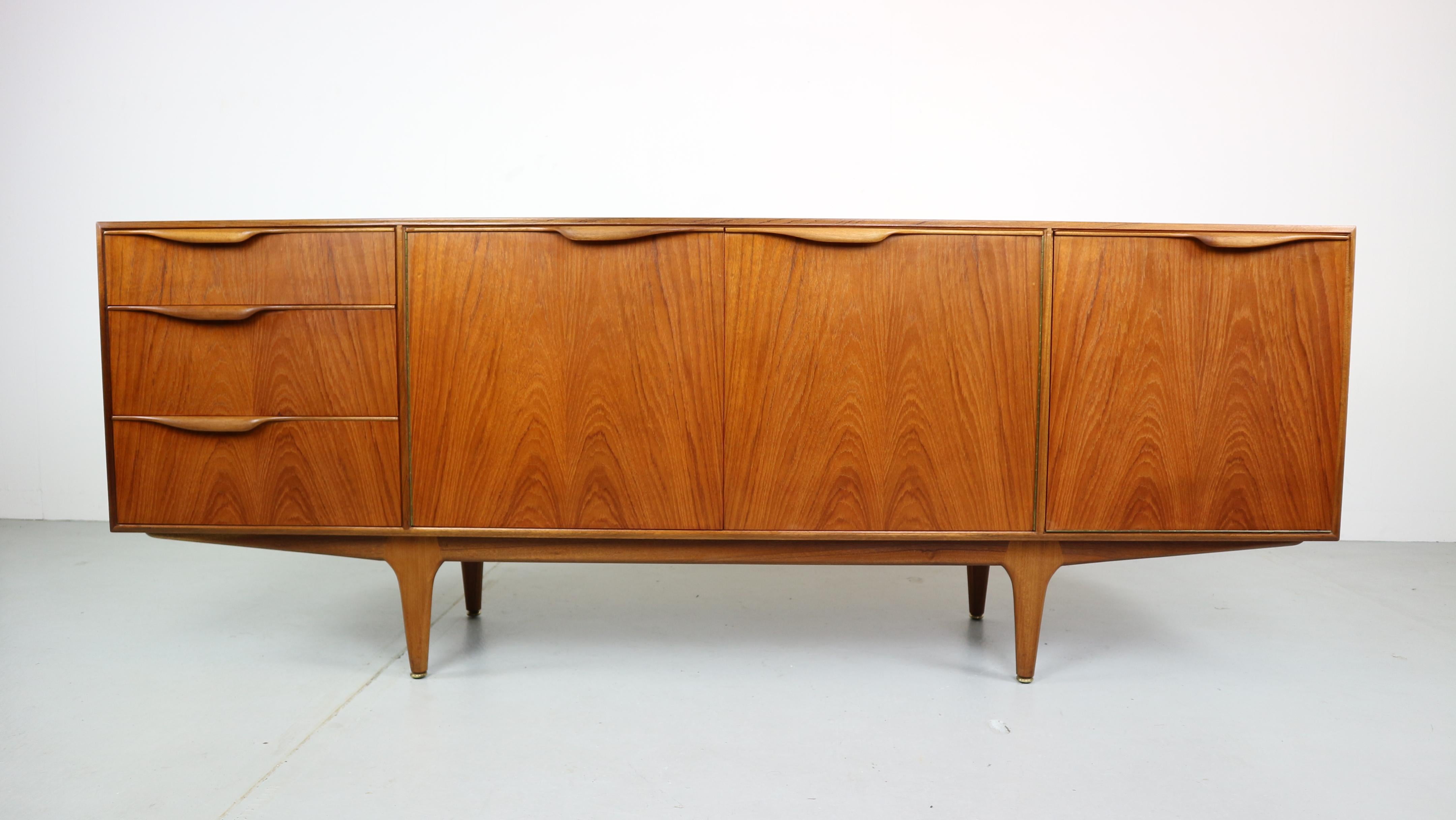 This beautiful 'Dunvegan' sideboard was produced by cabinetmaker A.H. McIntosh & Co from Kirkaldy, Scotland and designed by Tom Robertson. This sideboard comes in a very warm teak and features nicely shaped handles, giving it an organic character.