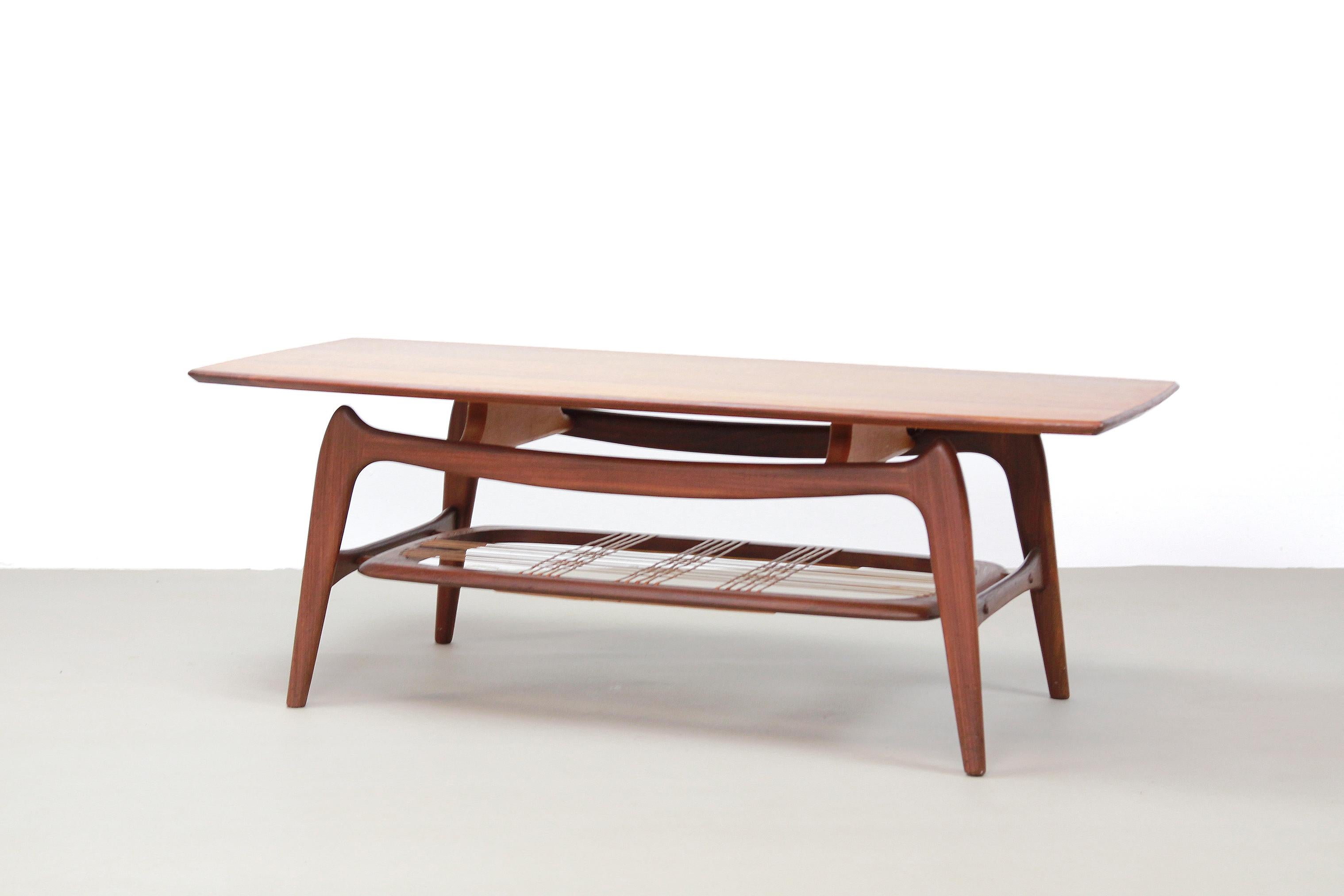 Beautiful organically designed coffee table by Louis van Teeffelen for WeBe. Made from solid teak 'insect legs' frame and teak veneered table top. Below the table top there is a webbing of rattan for, for example, magazines. The table is 42.5 cm