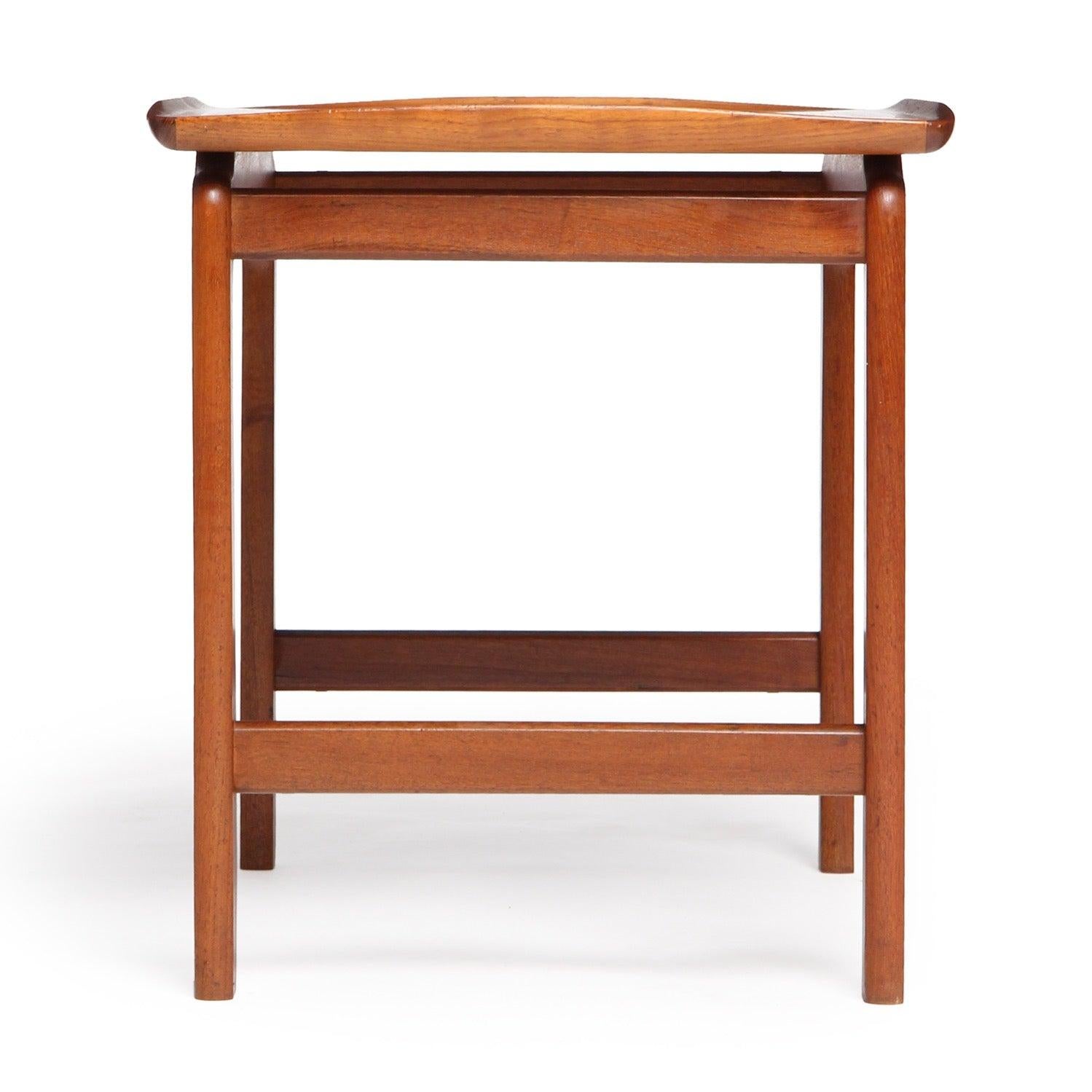 Table d'appoint en teck hautement figuré aux tons chauds.