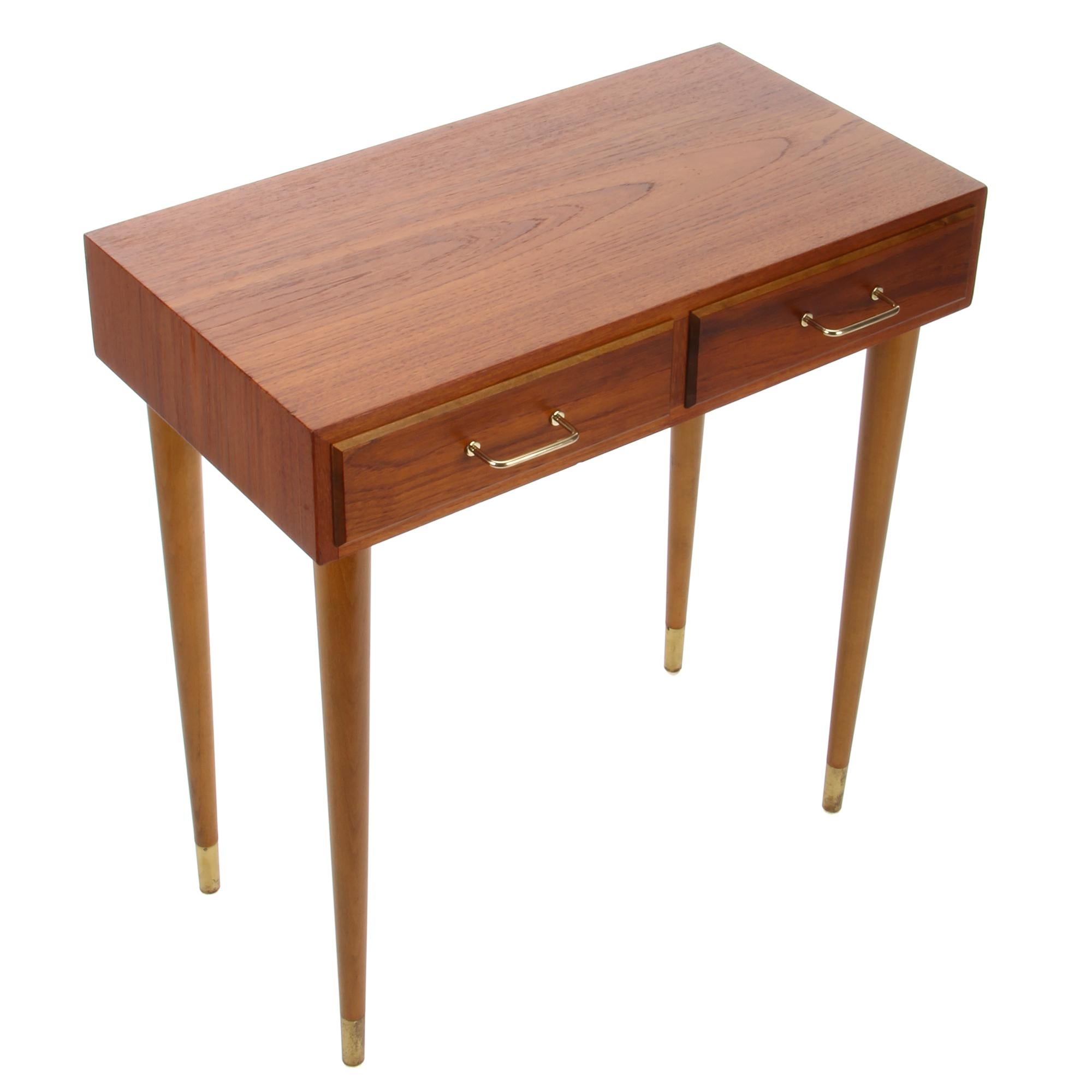 Teak entry table, 1960s Danish vintage end table or console table with drawers and brass handles, in very good vintage condition.

A tall midcentury piece with a narrow rectangular shaped teak body with tapered sliding dovetails joints, on top of