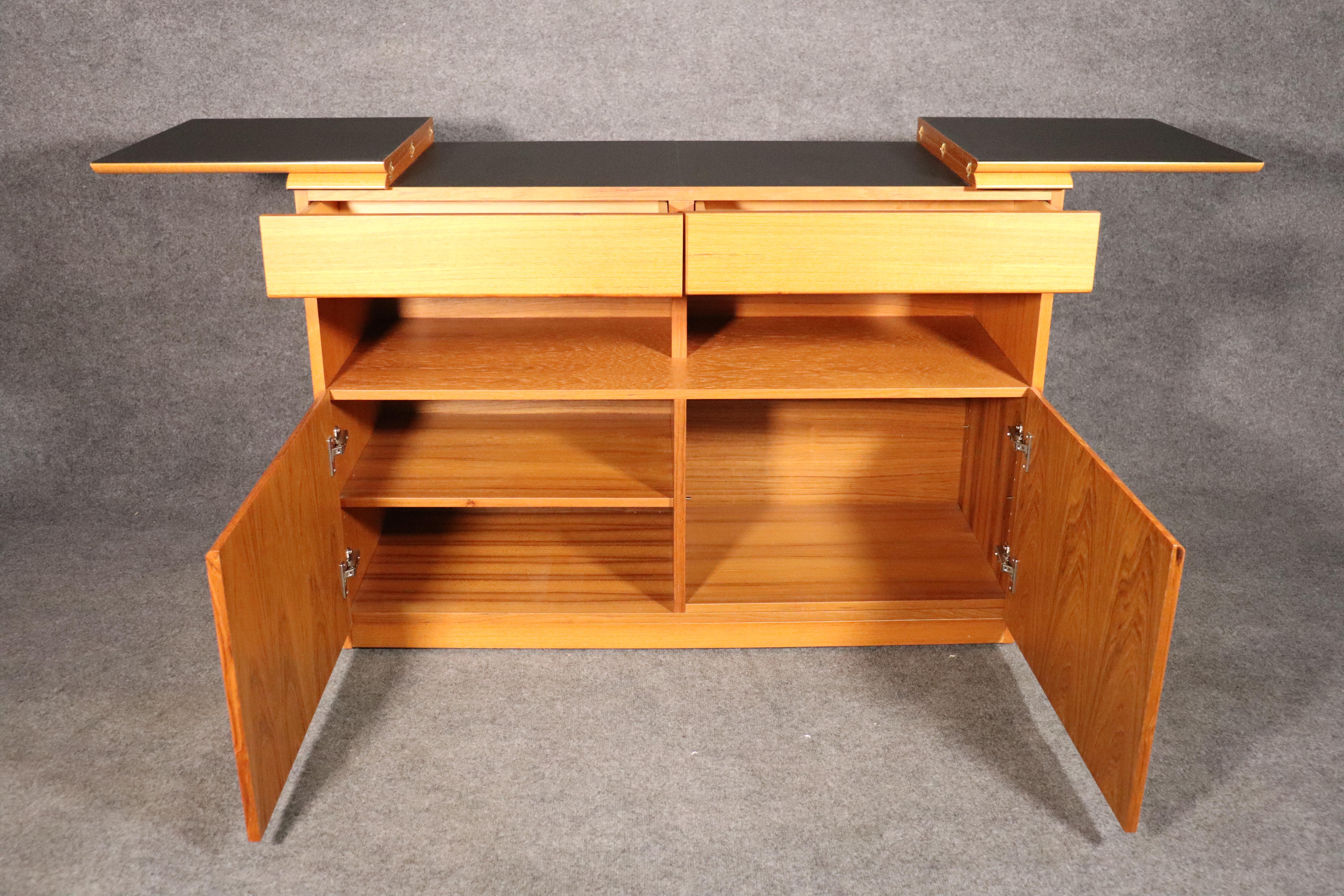 Danish Mid-Century Modern server with fold down top. Ample cabinet storage and flip top bar space with black laminate.
Open top: 69.75