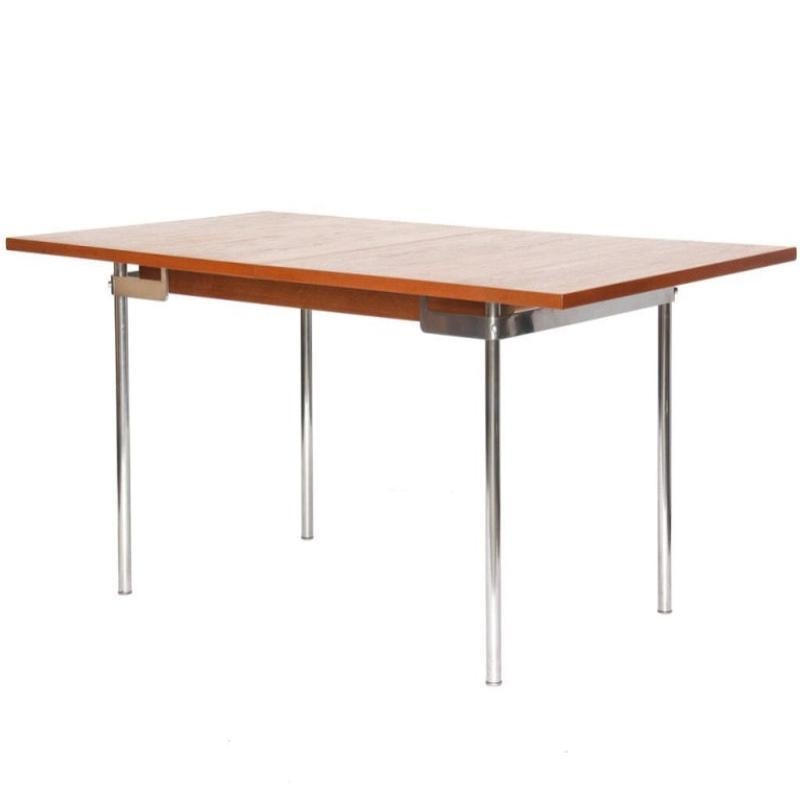 An extension dining table with a rectangular teak top on satin-chromed steel pipe legs. Leaves (16