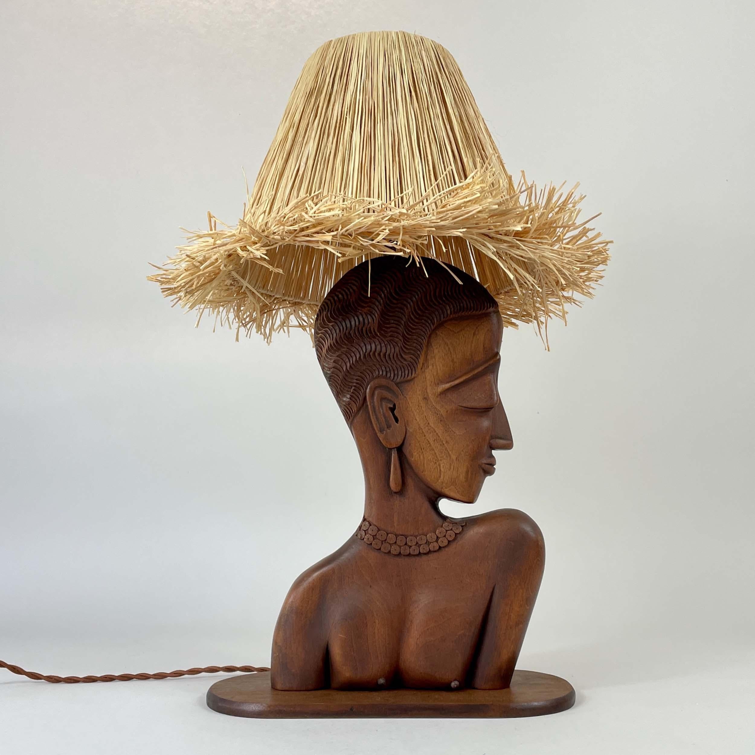 Cette lampe de table inhabituelle a été conçue et fabriquée en France dans les années 1950.

Le luminaire est doté d'une base en teck sculptée à la main représentant un buste de femme stylisé avec des traits de visage délicats, des cheveux détaillés