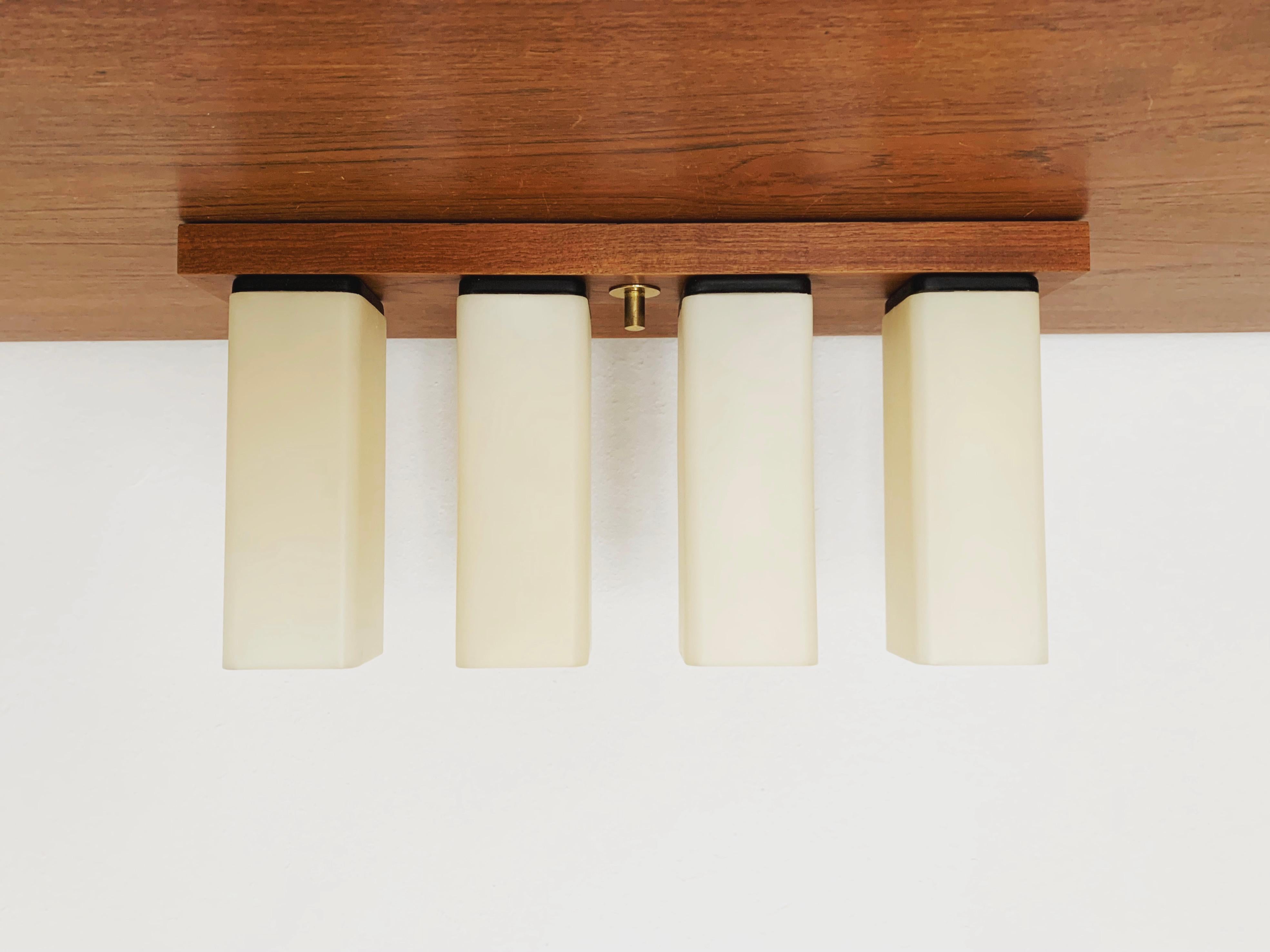 Beautiful teak ceiling lamp from the 1960s.
The design is very unusual.
The shape and the plastic lampshades create a warm and very pleasant light.

Condition:

Very good vintage condition with slight signs of wear and tear due to age.

The pictures