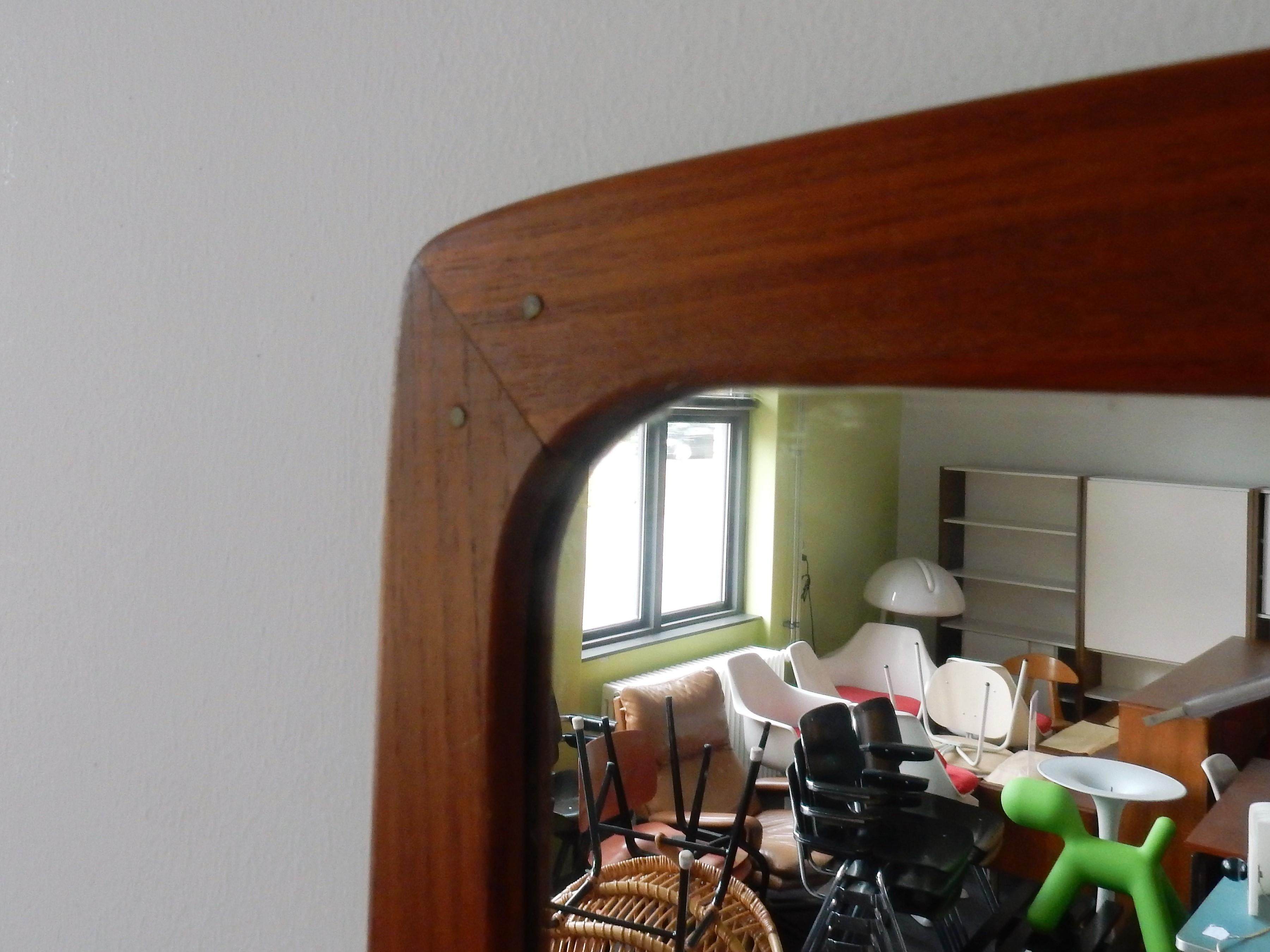 Very nice mirror in a teak frame. The rectangular frame has brass nails where the frame parts connect. This item is in a very good condition with some signs of age and use.