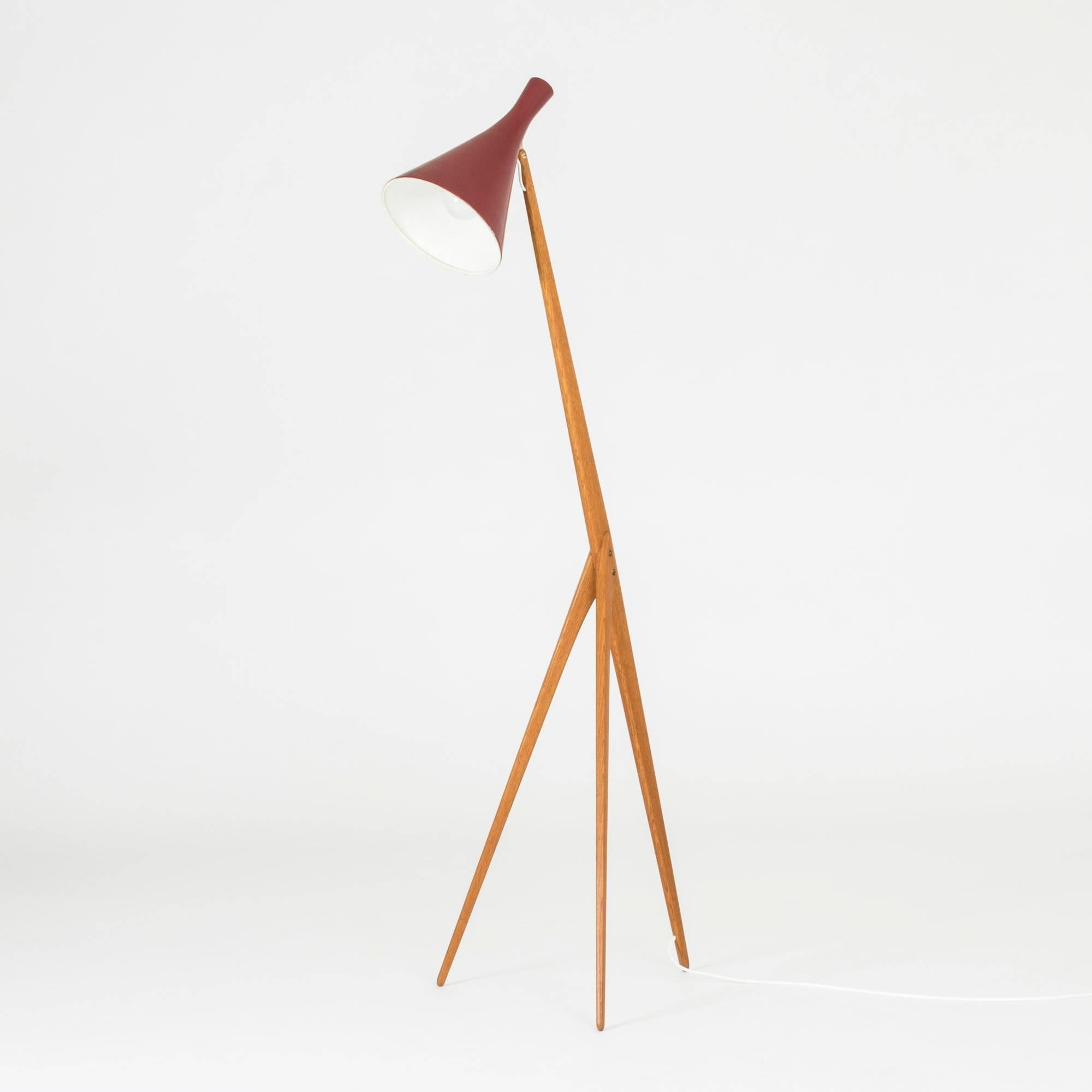 Amazing floor lamp by Uno and Östen Kristiansson, made from solid teak with a dark red lacquered shade and brass details. The electrical cord is fitted into a slit running down the length of the back leg.
