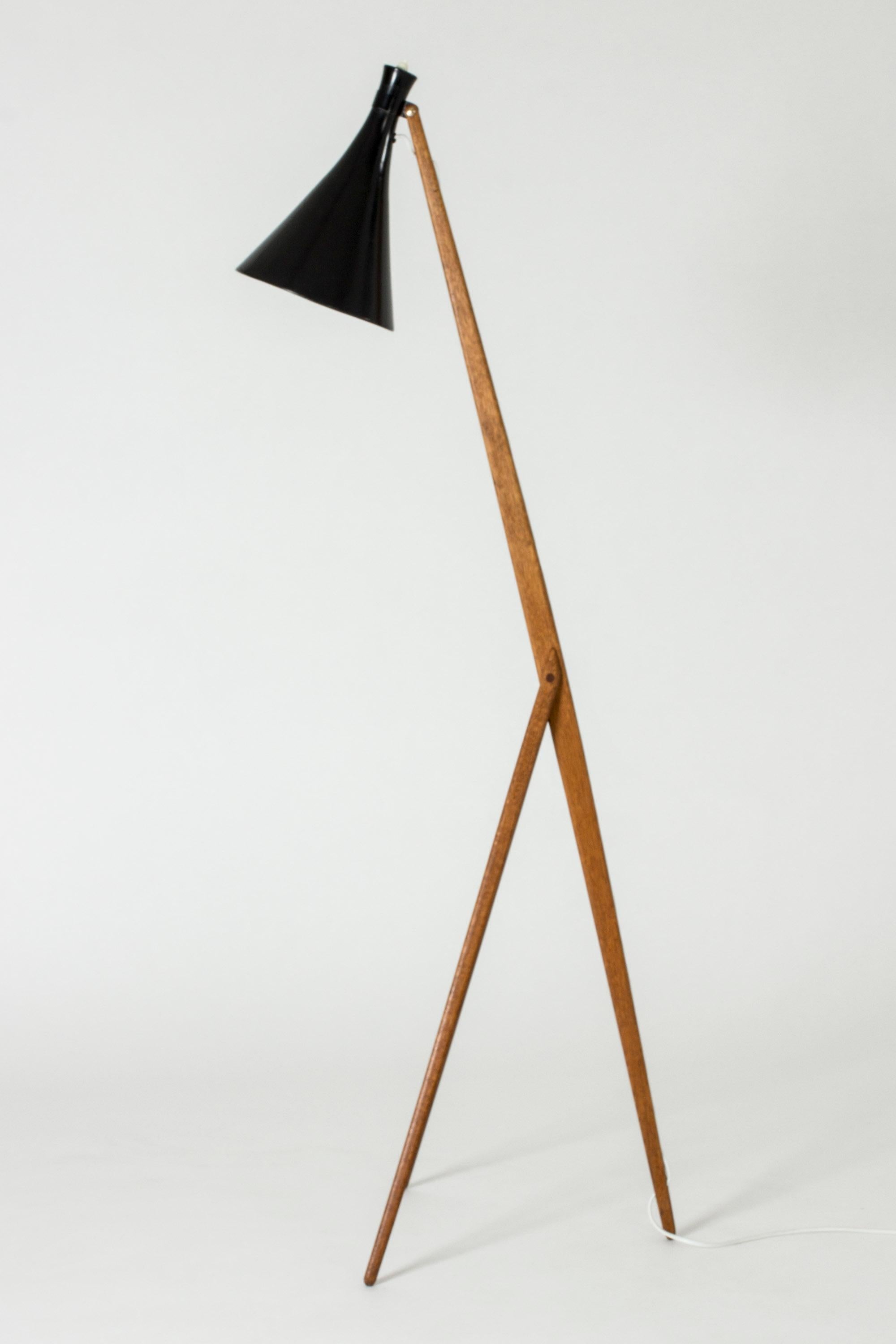 Amazing “Giraffe” floor lamp by Uno and Östen Kristiansson, made from solid teak with a black lacquered shade and brass details. The electrical cord is fitted into a slit running down the length of the back leg.