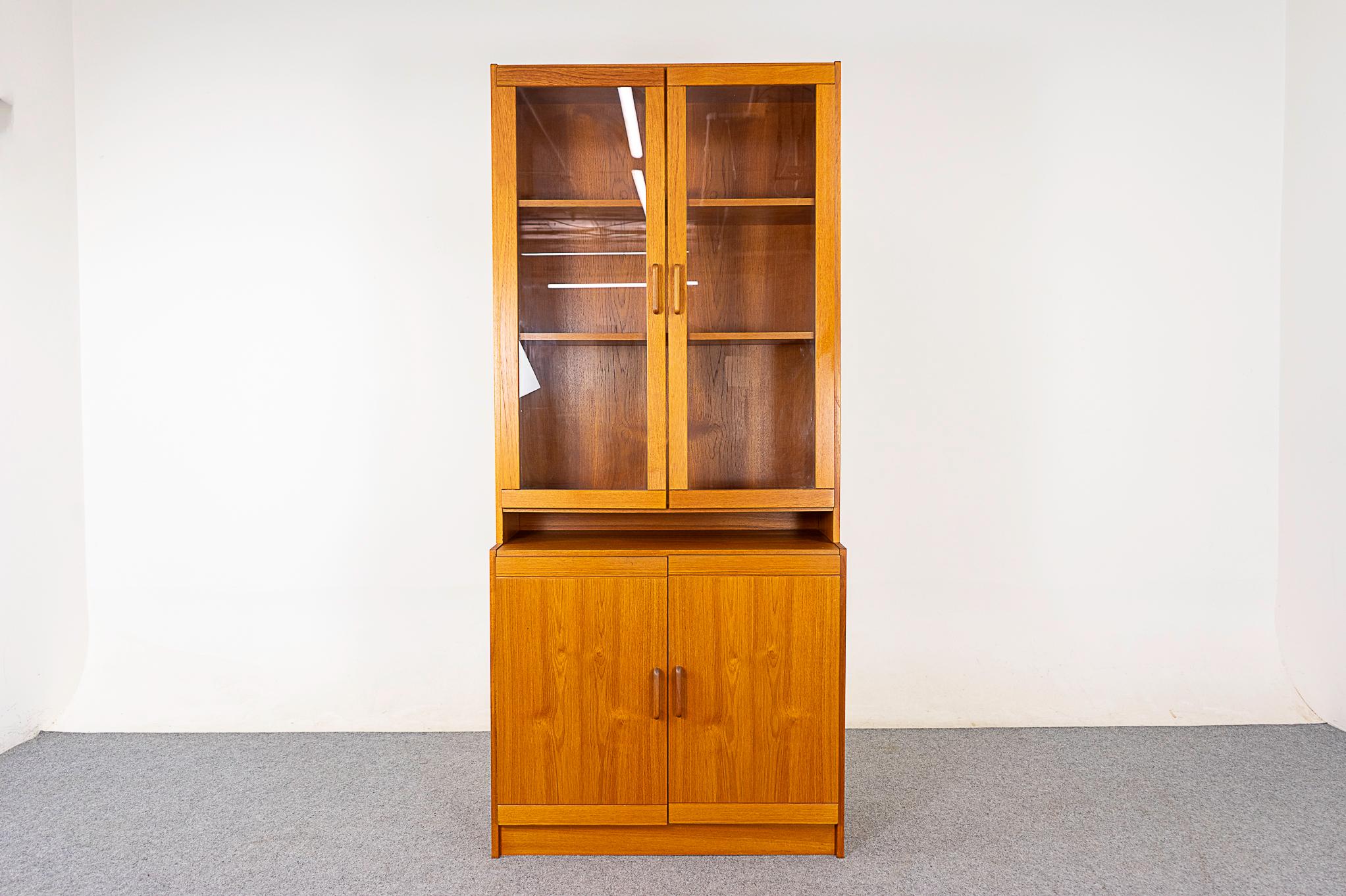 Teak Danish cabinet, circa 1970's. Practical storage solution, lower cabinet with adjustable shelf and glass hutch with 2 adjustable shelves. Display your treasures, dust free! 

Sold as is, nice condition, very minor wear & tear. 
