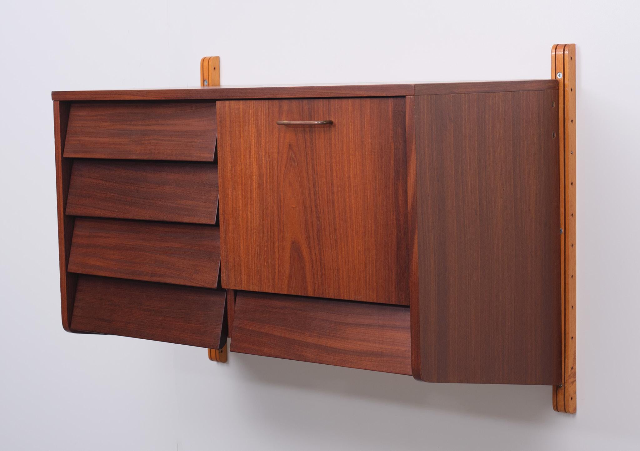 Très belle armoire suspendue en bois de teck. 2 montants 5 tiroirs 1 abattant 
Poignée en laiton. Beaucoup d'espace de rangement. Design néerlandais des années 1960. Très bon état.