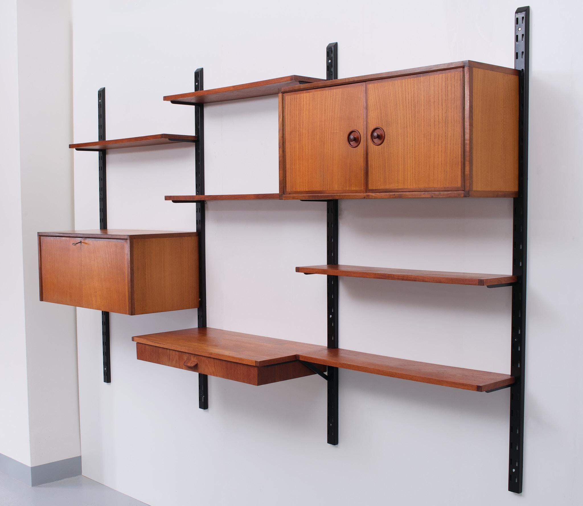 Very nice Teak wood hanging wall system. 4 Steel uprights, comes with 
3 Cabinets and 5 shelves. Easy to install. Attributed to Pilastro 1960s Holland.