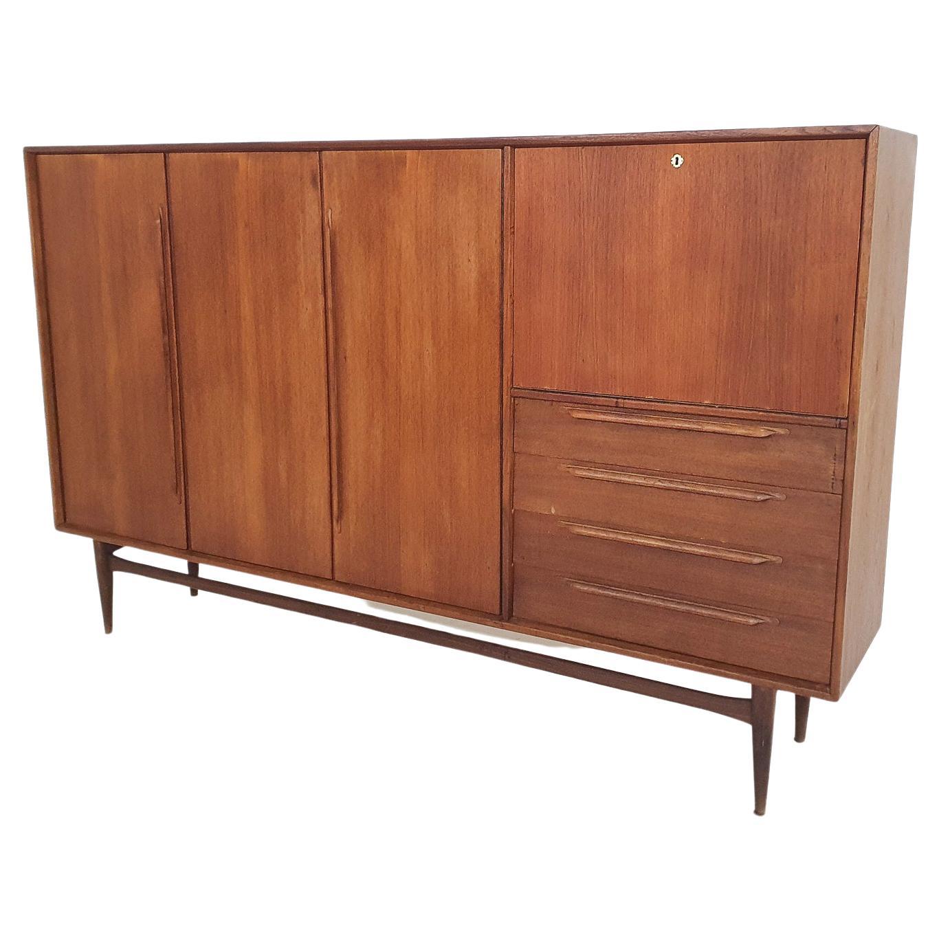 Teakholz-Highboard von Heinrich Riestenpatt für RT Mobel. Das Schloss war kaputt, also haben wir es ausgetauscht und eine Goldplatte über dem Schlüsselloch angebracht.
Einige Flecken auf der Oberseite des Schrankes.