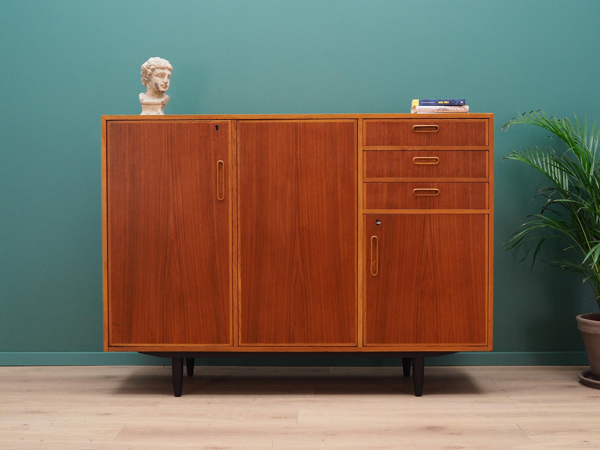 Superb highboard from the 1960s-1970s. Scandinavian design, Minimalist form. Furniture finished with teak veneer. Highboard has a spacious interior with shelves and three packed drawers. Key included. Preserved in good condition (minor bruises and