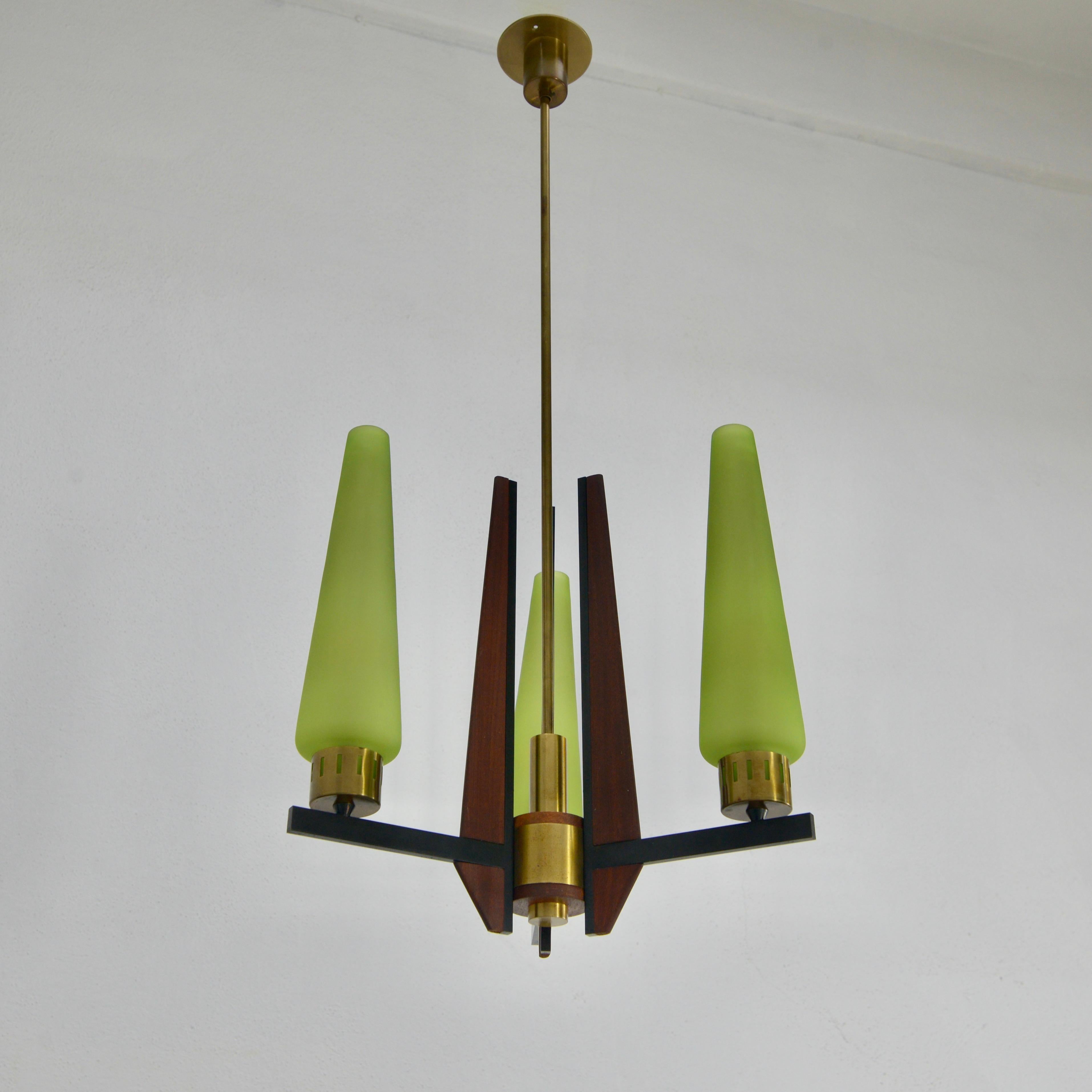 Classic of the period 1950s Italian teak wood and brass chandelier. Original green glass from the period With 3-E12 candelabra based sockets (1) per shade. Wired for use in the US. Light bulbs included with order.
Measurements:
OAD 37”
Diameter