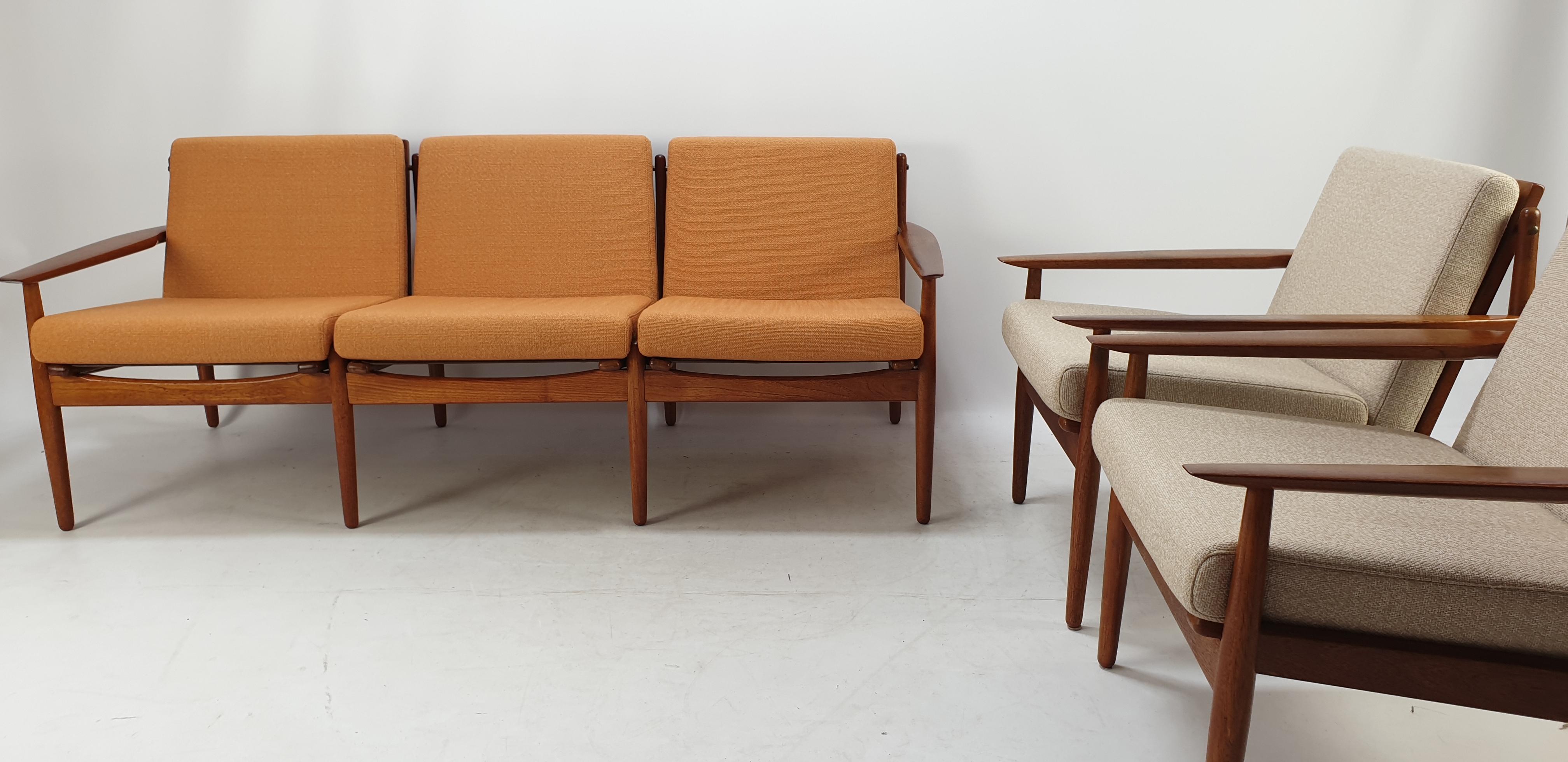 This elegant living room set was designed by Svend Åge Eriksen and manufactured in Denmark by Glostrup Møbelfabrik circa the 1960s. The beautiful set features a 3-seater sofa and two lounge chairs. The pieces have teak wood frames and sculpted