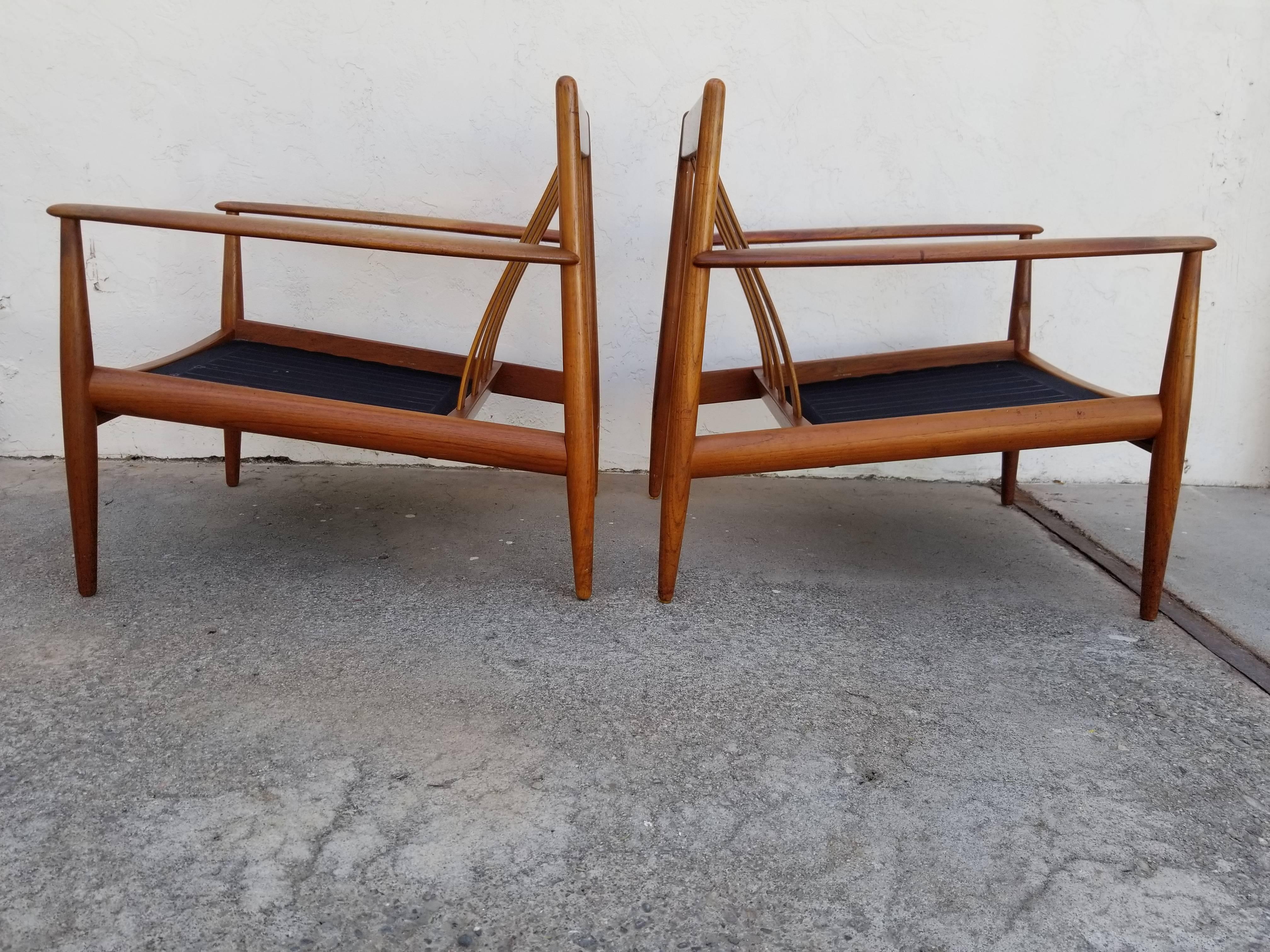 Early pair of Grete Jalk teak lounge chairs by France & Daverkosen, Denmark, circa. 1960. Both chairs retain their original makers marks. Original cushions intact, but have wear. Allows opportunity to re-upholster in fabric of your choice while