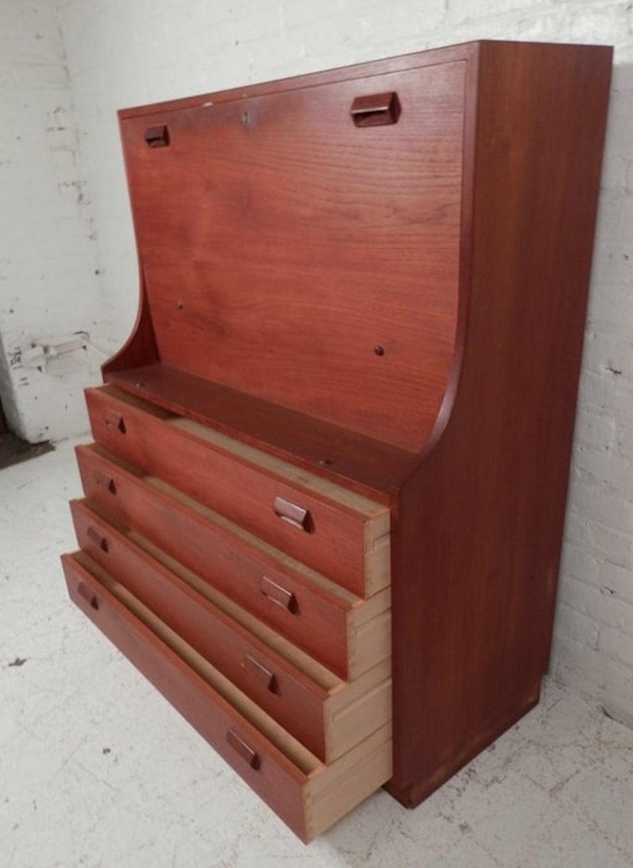 Vintage Danish modern secretary desk. Fold down table with office storage and four dresser drawers. Classic Danish modern design with wood handles and beautiful teak wood grain.
Please confirm location NY or NJ