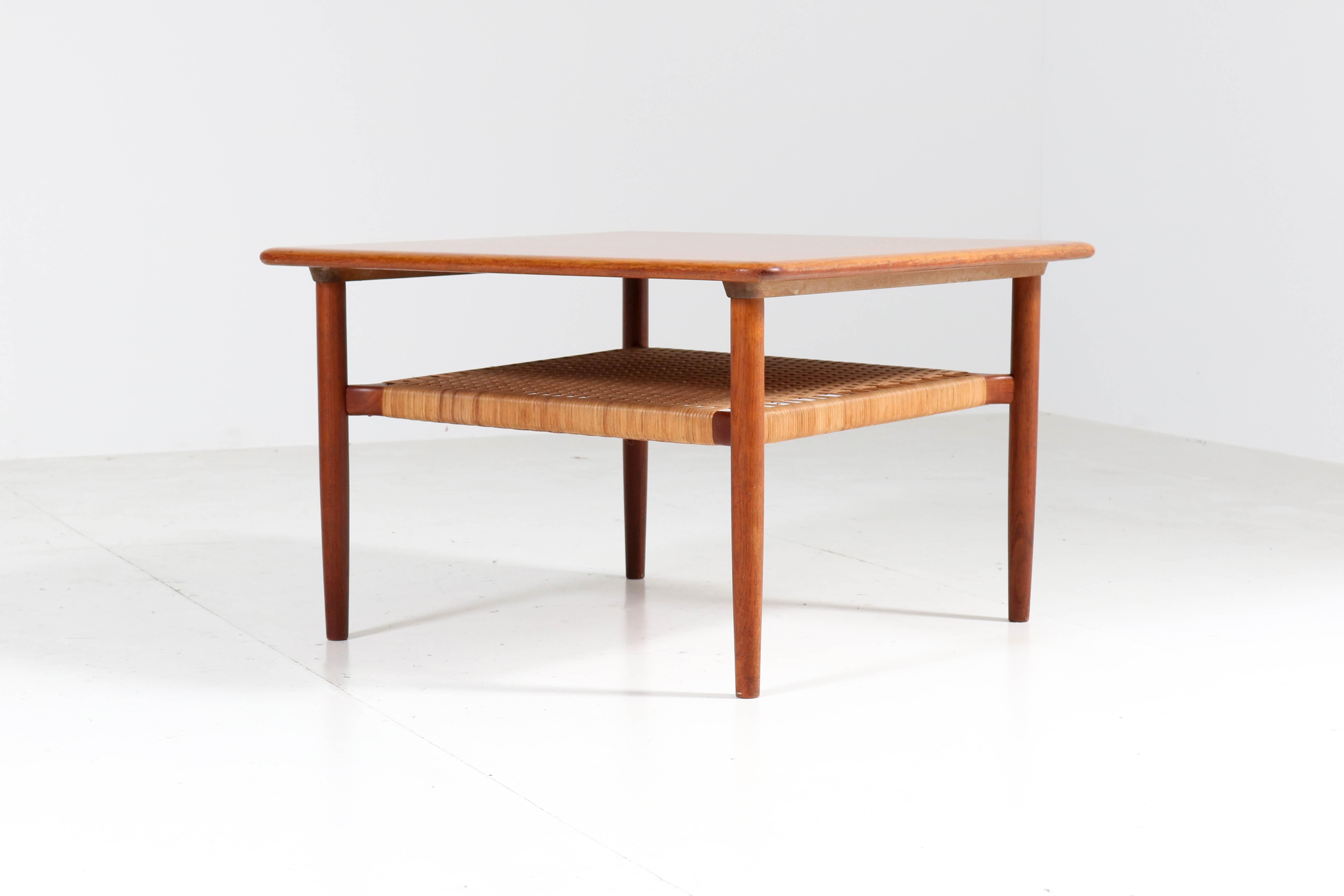 Wonderful Mid-Century Modern coffee table.
Design by Gunnar Schwartz.
Striking Danish design from the 1960s.
Solid teak with woven cane under shelf.
Marked with metal tag, see image.
In good original condition with minor wear consistent with