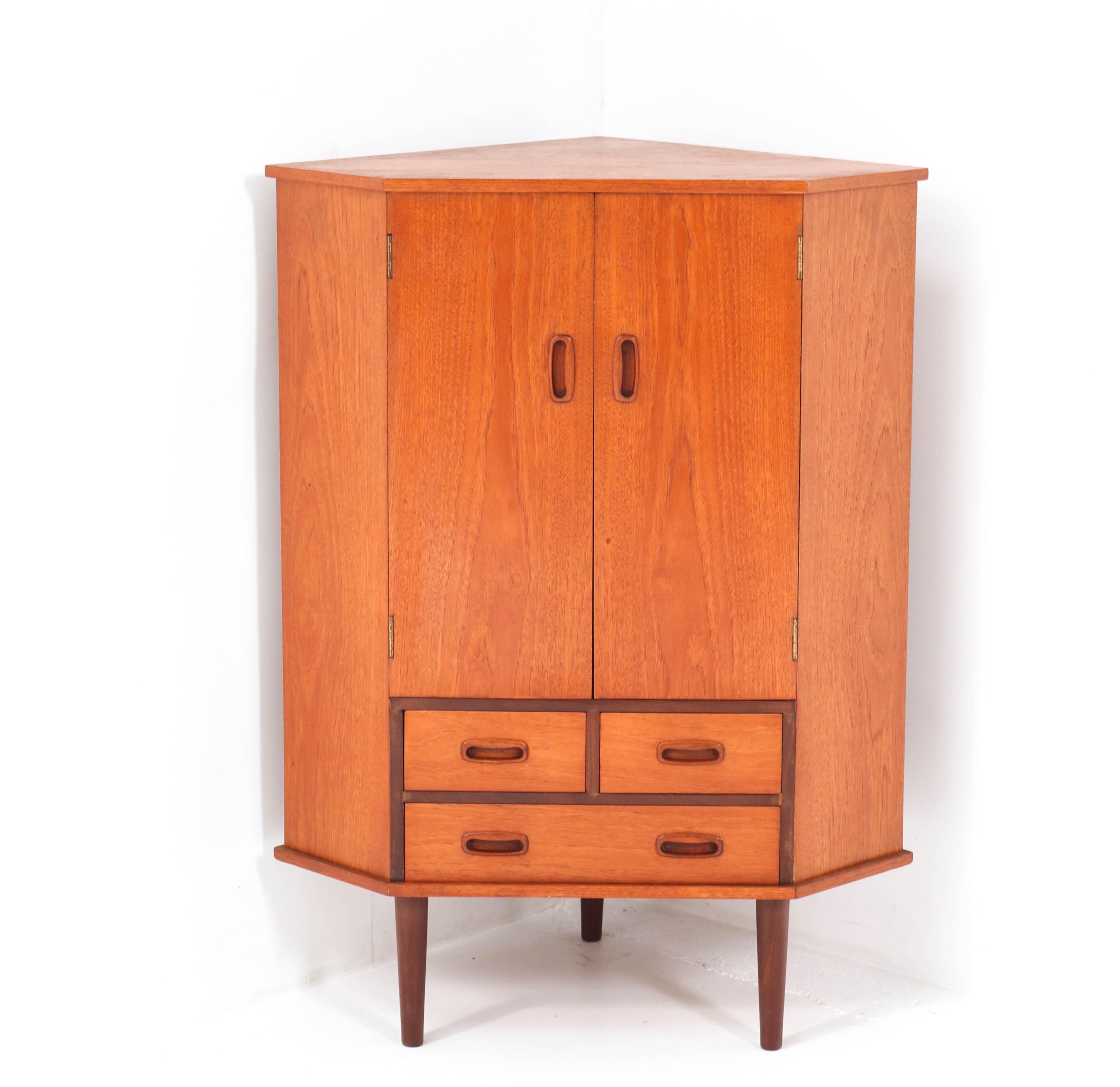 Stunning Mid-Century Modern corner cabinet or cupboard.
Striking Dutch design from the 1960s.
Solid teak and teak veneer.
Three original drawers.
In very good original condition with a beautiful patina.