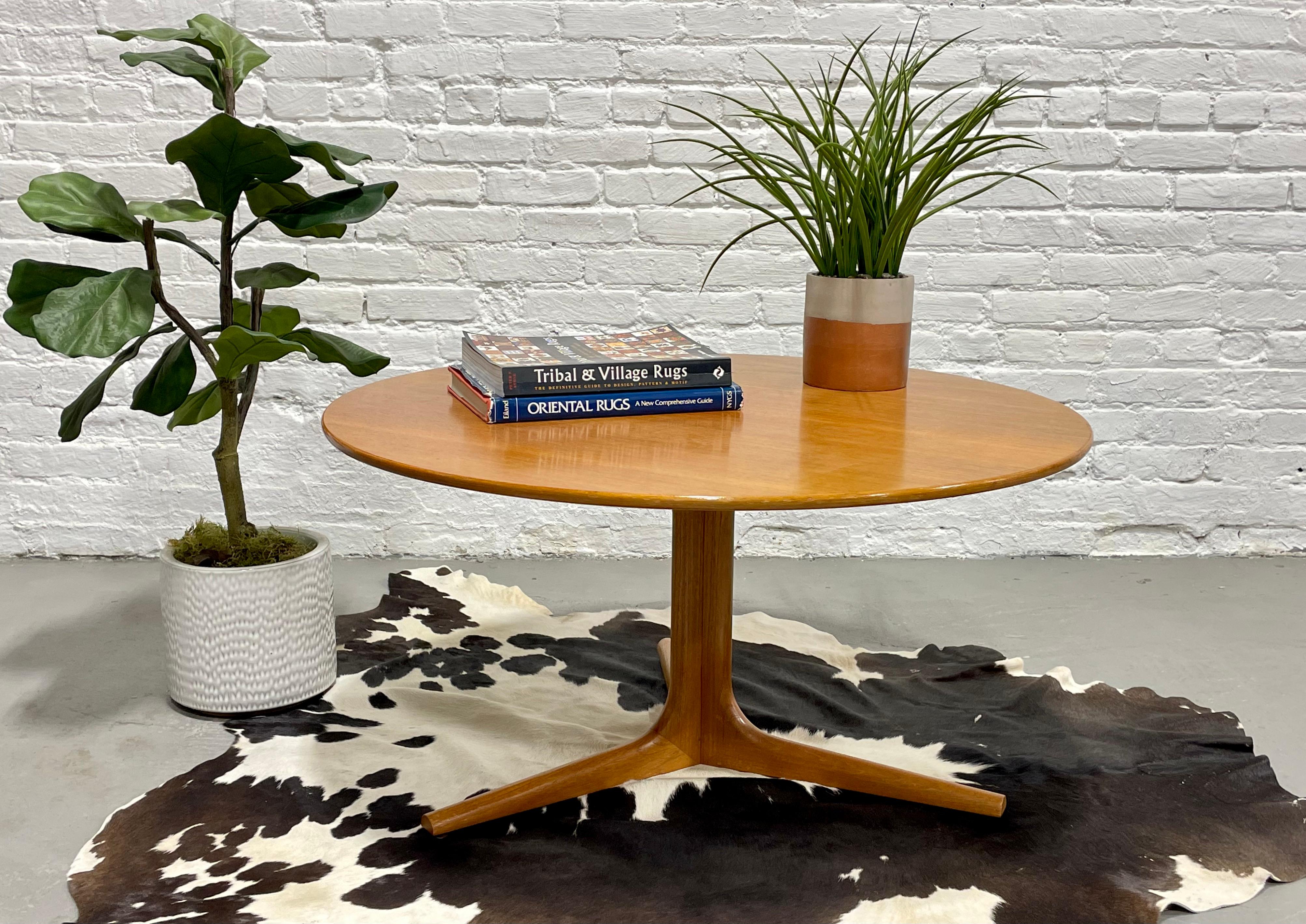 Teak Mid-Century Modern Danish round coffee table, circa 1960s. Solid + sturdy table with unique three legged base design. If you've been searching for a round mid century coffee table, you know they are not easy to find. This stunning table will