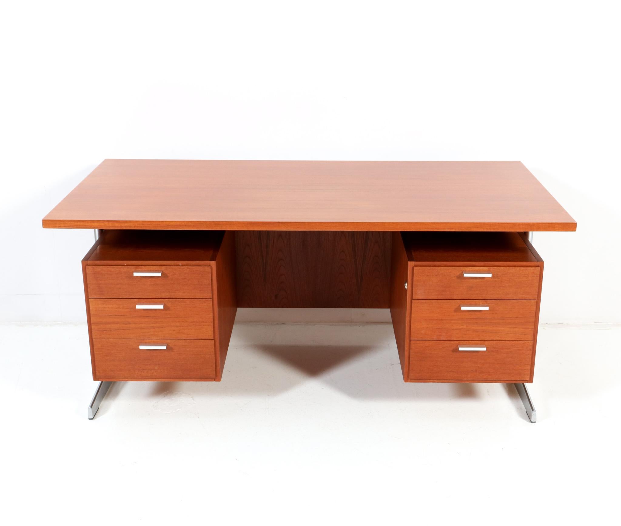 Stunning and elegant Mid-Century Modern executive desk.
Design by Cees Braakman for Pastoe.
Striking Dutch design from the 1960s.
Two chrome-plated metal legs with the original teak veneered base which has six original drawers.
One drawer is