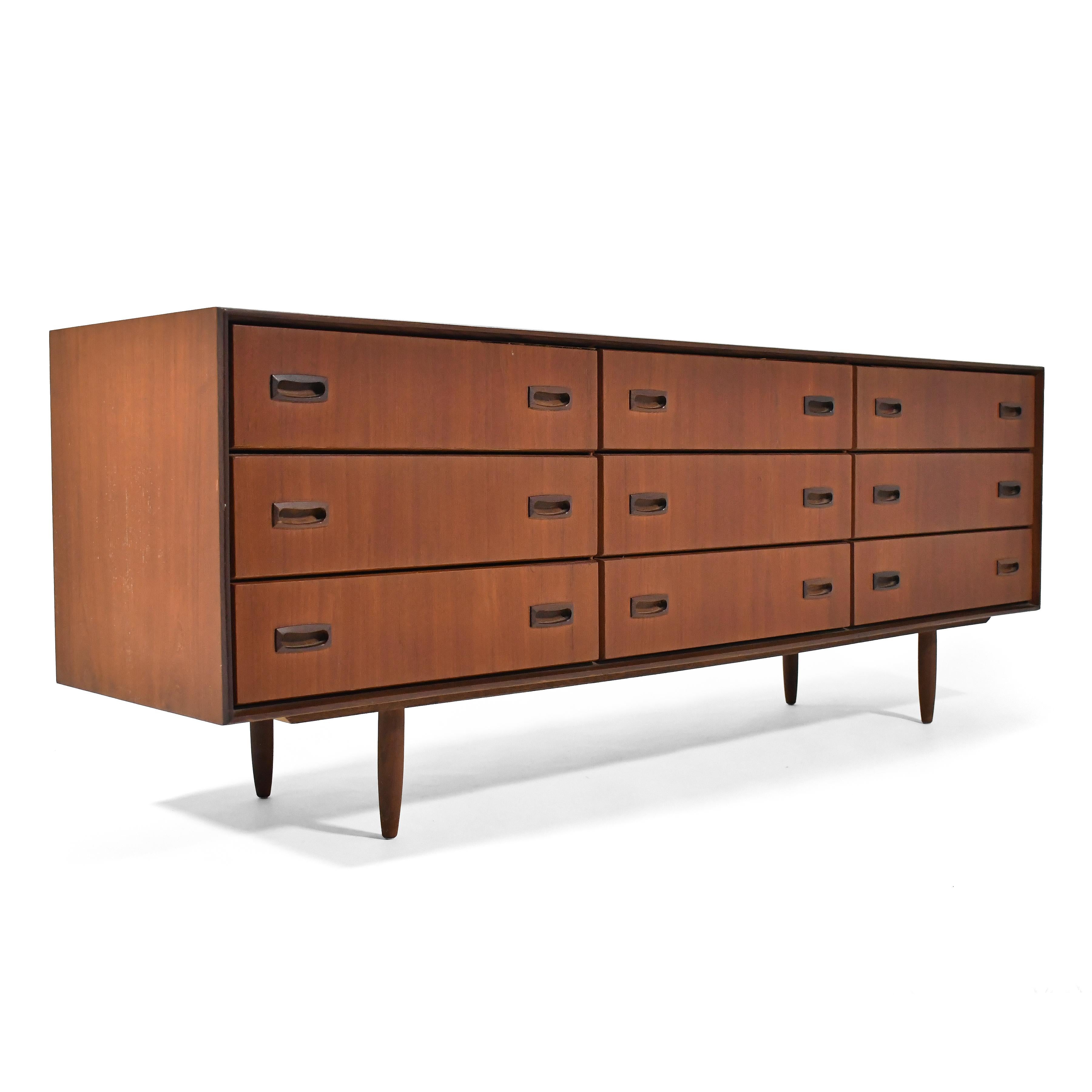 This nicely tailored cabinet in teak features nine drawers with sculptural pulls and beveled drawer-fronts all supported by tapered legs.

28