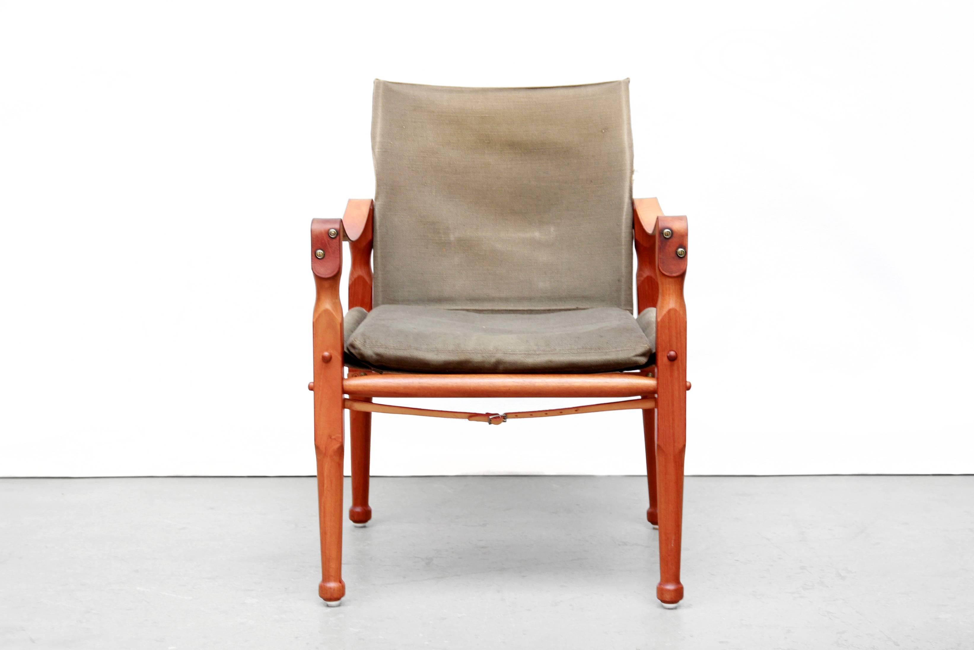 Midcentury modern Safari chair attributed to Danish designer Kaare Klint, produced in Denmark in the 1950s. 
This model is made of solid teak, beautifully patinated green canvas and cognac leather armrests and belts. 
Truly a unique vintage