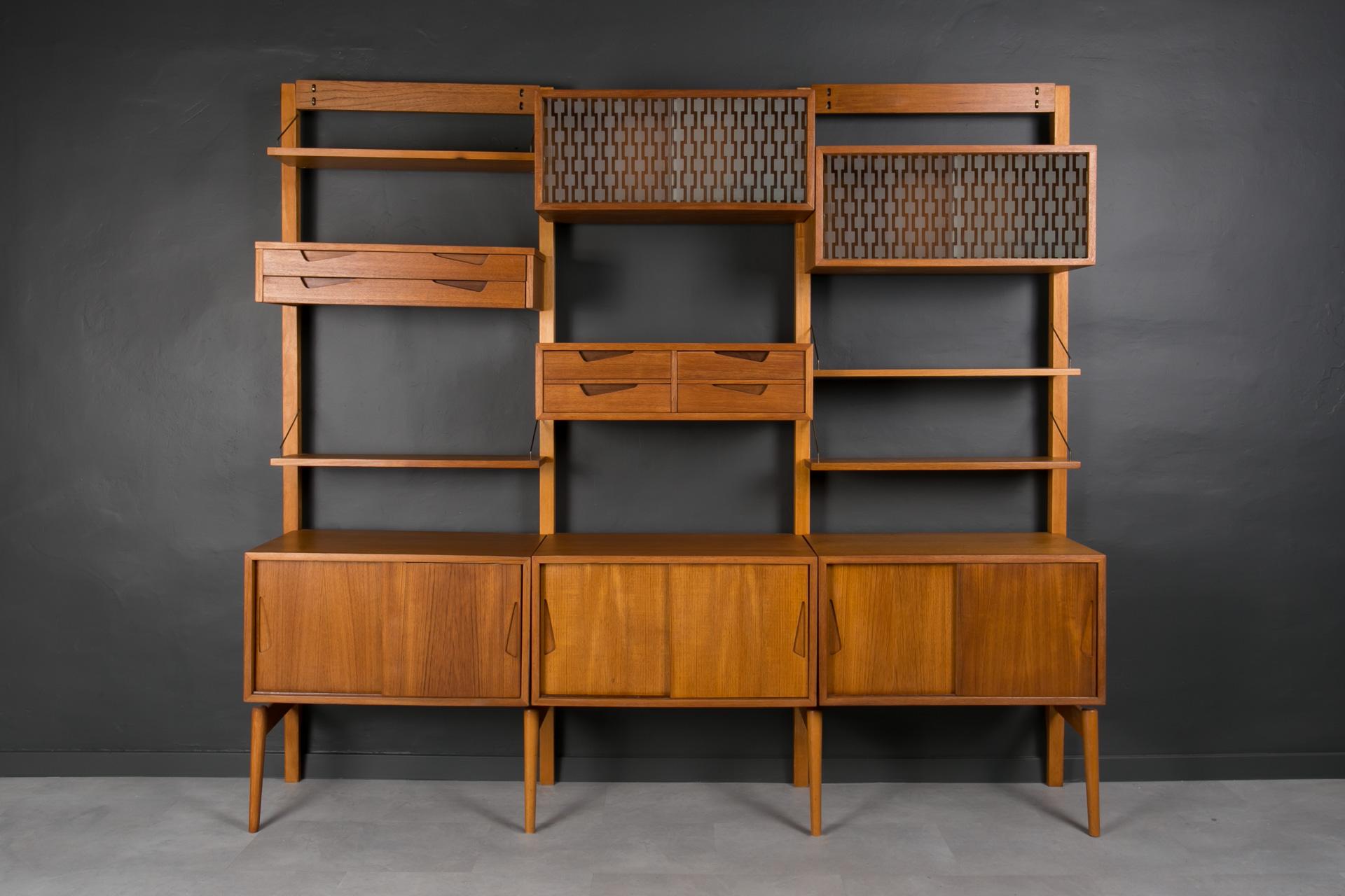 This is a smartly designed teak modular wall unit produced in Norway around 1960s by Brodrene Jatog Mobelfabrik, most probably designed by Kjell Riise. It is made of teak wood and preserved in very good original condition, the wooden surface is