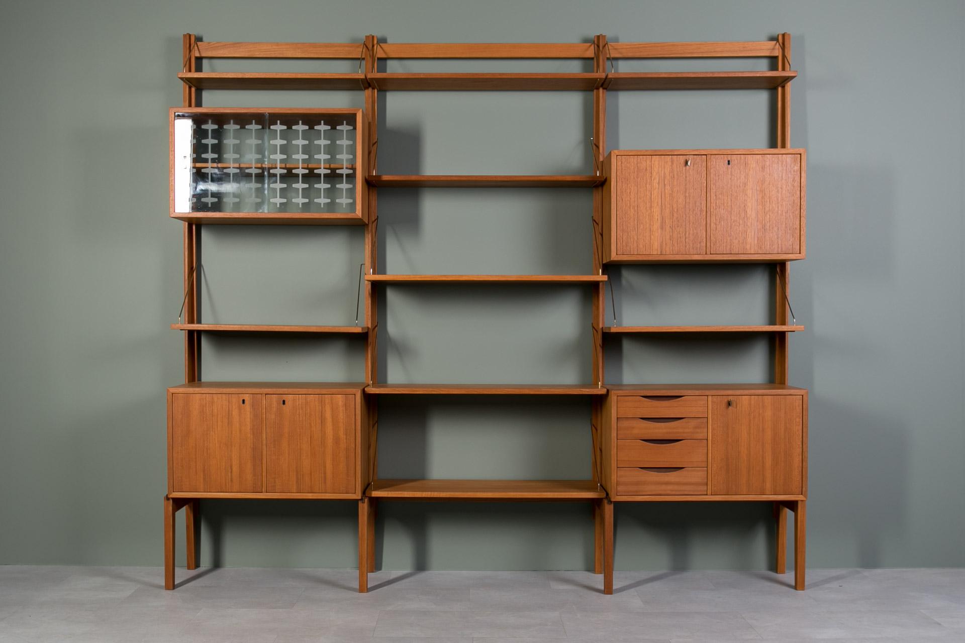 This smartly designed teak modular wall was unit produced in Norway around 1960s by Bruksbo and still has original labels on each piece. It is made of teak wood and was gently restored, old coating was removed and the whole piece was refinished with