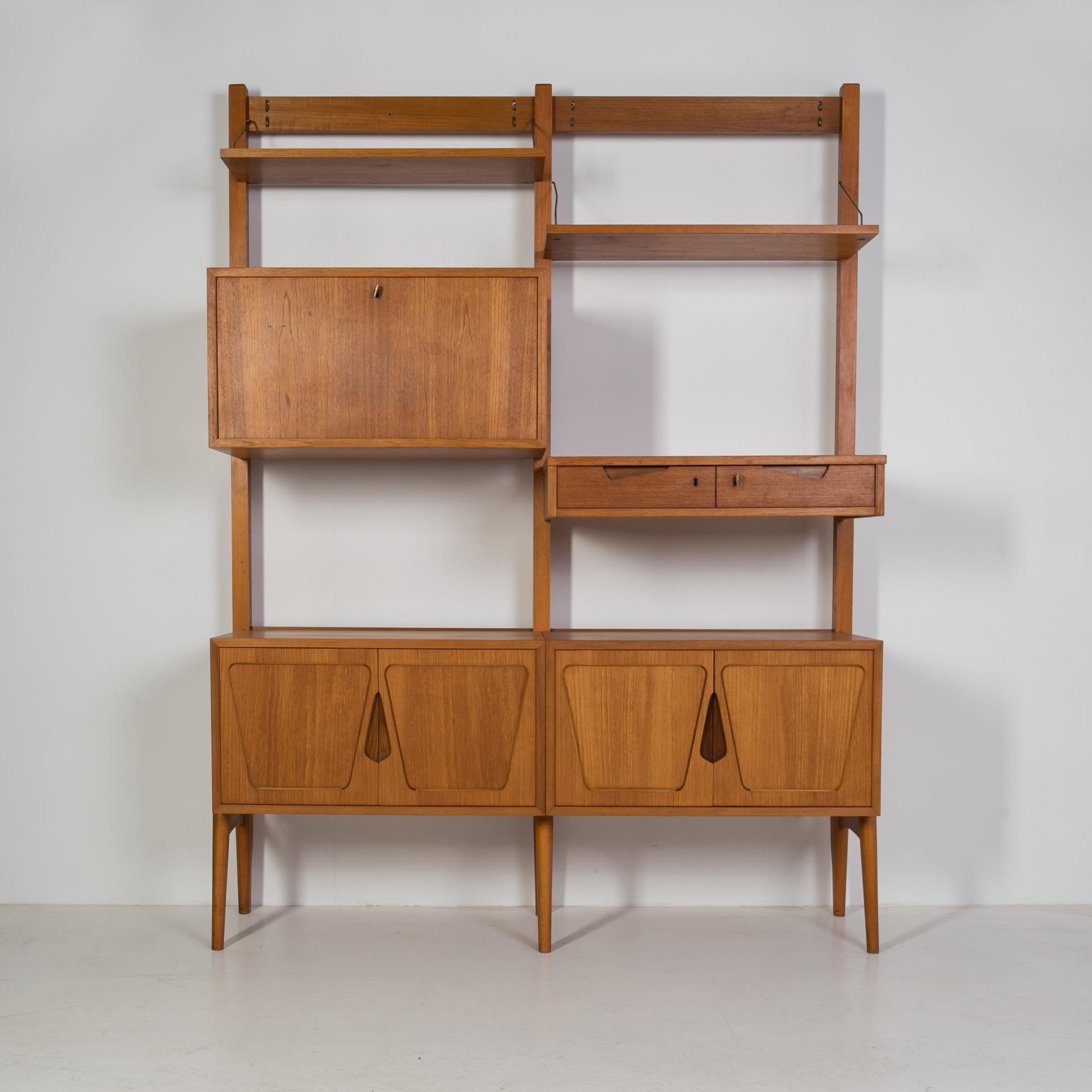 This smartly designed teak modular wall unit was produced in Norway around 1960s by Rival Brodrene Jatogs and still has original label in one of the cabinets.. It is made of teak wood and was gently restored, old coating was removed and the whole