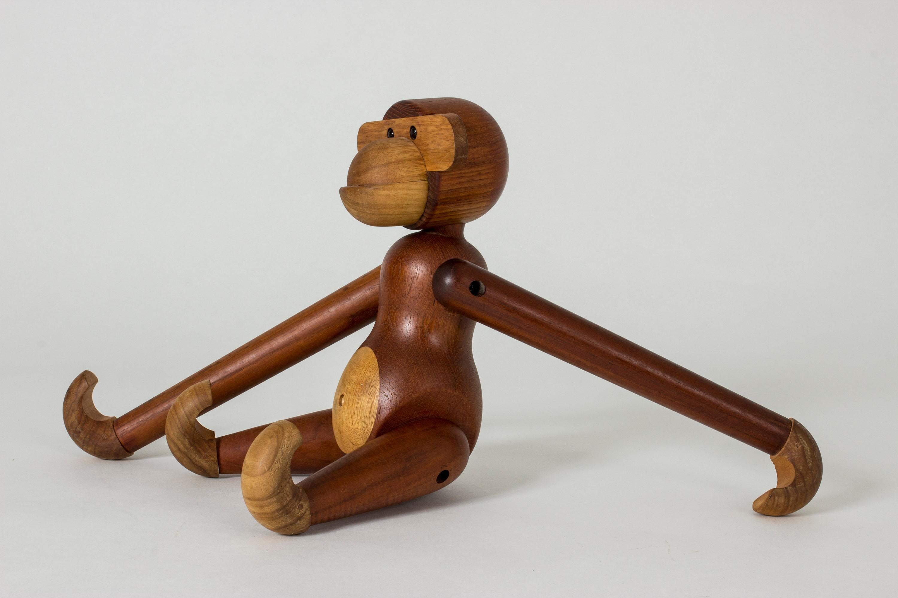 Large iconic teak monkey figurine by Kay Bojesen. Endearing, animated design. The limbs are fully movable and the monkey can hang by its hands or feet from a shelf or back of a chair.