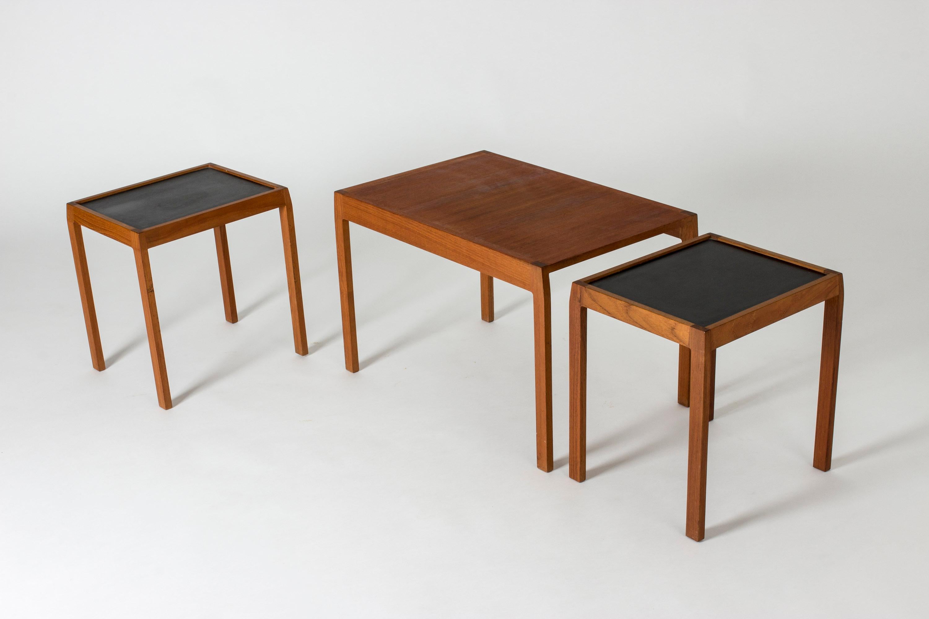 Neat nesting table by Svante Skogh, made from teak. Two smaller tables fit under the large one, both with formica table tops. Beautifully bevelled corners on the table tops make an interesting silhouette.