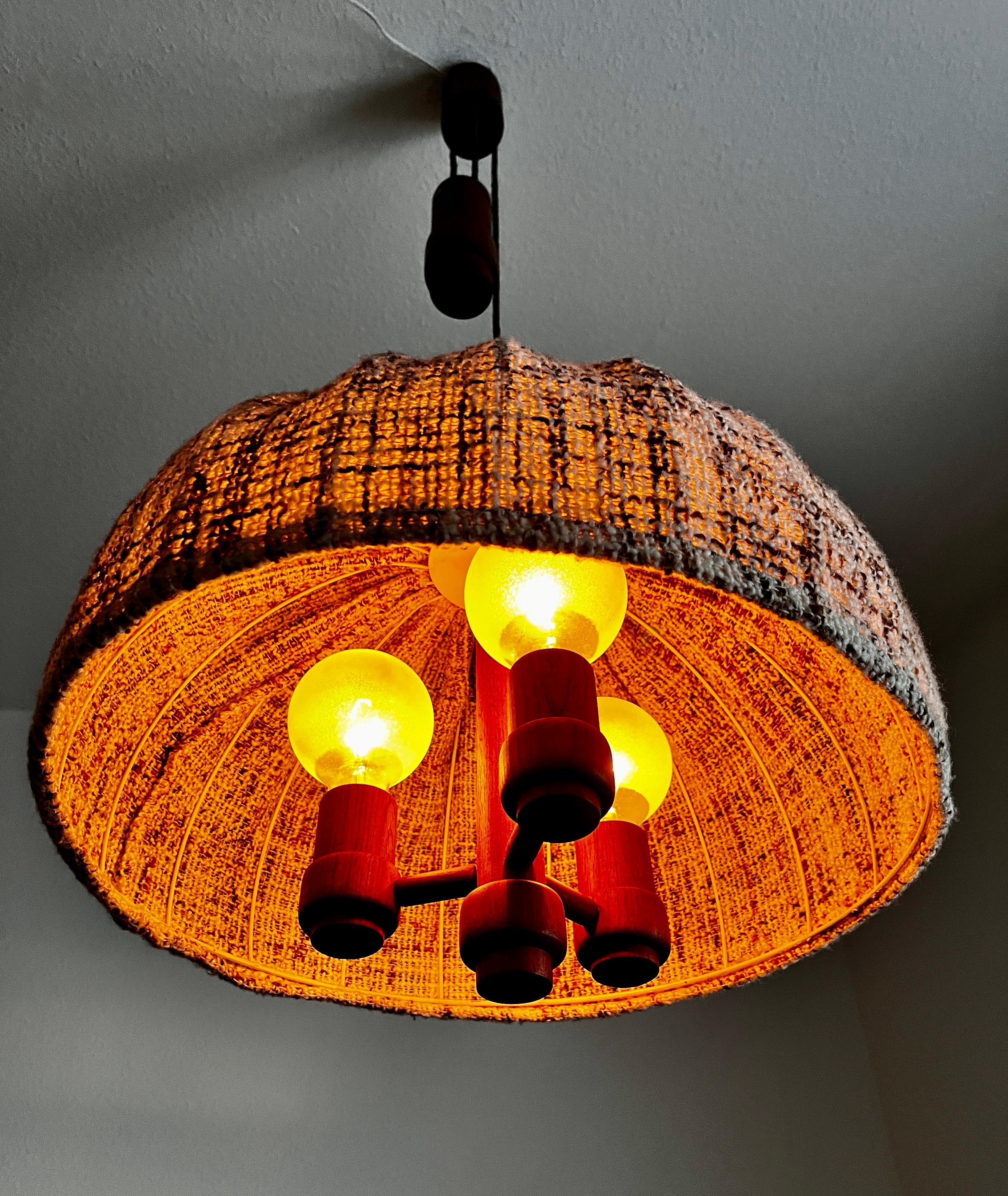Una lámpara de techo de madera de Domus de la década de 1960. El cuerpo de la lámpara es de teca. La pantalla es de tejido de lana.
La lámpara tiene un maravilloso diseño escandinavo.

La longitud de la lámpara puede ajustarse mediante el mecanismo