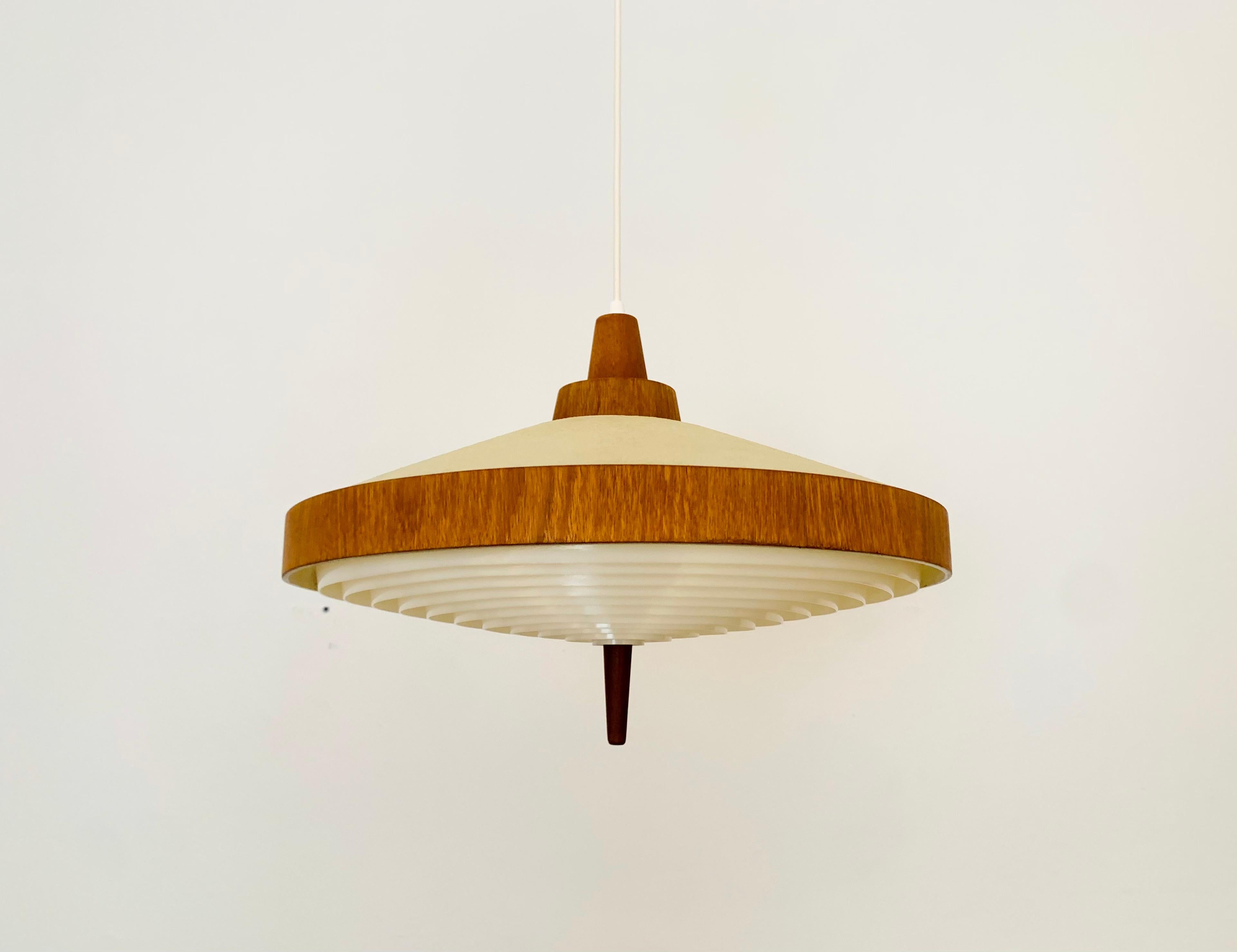 Exceptionally beautiful pendant lamp from the 1960s.
The design is very unusual.
The shape and materials create a warm and very pleasant light.

Condition:

Very good vintage condition with slight signs of age-related wear.
The plastic parts are in