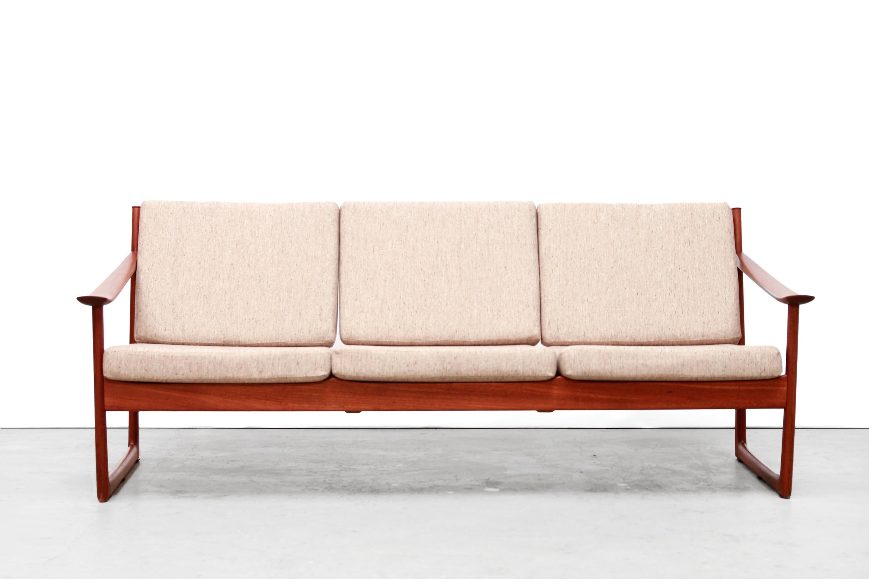 Beautiful three-seat sofa designed by the Danish duo Peter Hvidt and Orla Molgaard Nielsen in the 1960s.
This sofa has unique sled base and beautifully designed wide armrests. The sofa is made of solid teak and has new cushions and new woolen