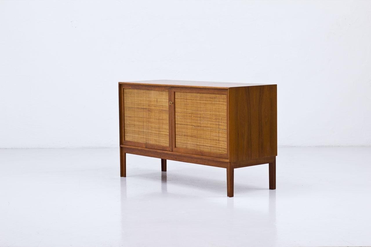 Sideboard designed by Alf Svensson, manufactured by Bjästa Möbelfabrik in
Sweden during the 1960s. Made from teak with two doors panel covered by
rattan webbing. Brass key. Inside in birch with adjustable height shelves. Stamped by maker.
 