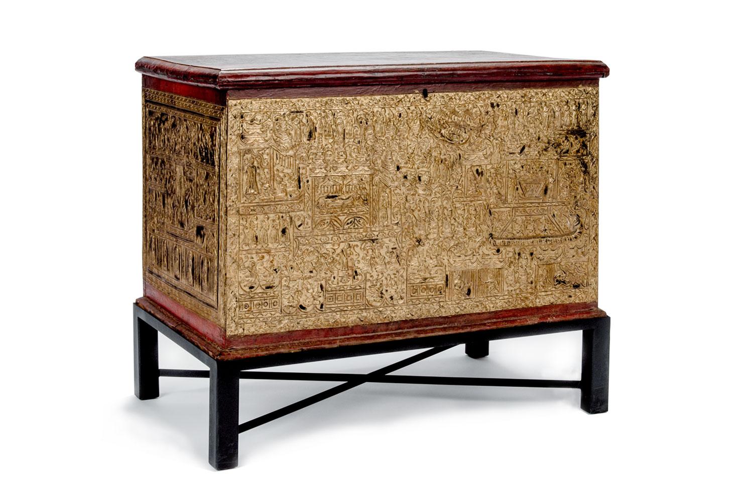19th century teak Burmese manuscript chest. Made from teak and lacquered red with gold leaf accentuating depictions of the life of Buddha. Lid lifts open and sits on steel stand.

Measures: 38.5