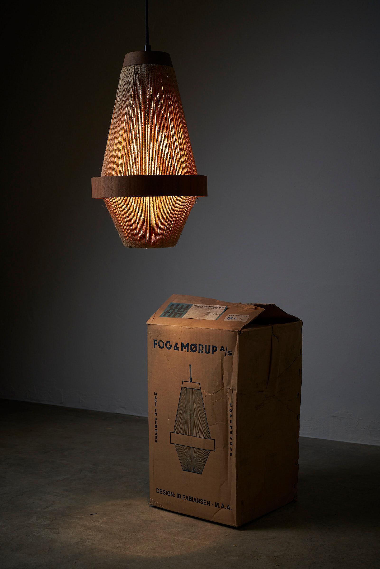 Introducing the exquisite hanging lamp designed by IB Fabiansen for Fog&Mørup, a Danish design gem that beautifully combines teak wood and rope to create a truly captivating lighting piece.

Crafted with meticulous attention to detail, this