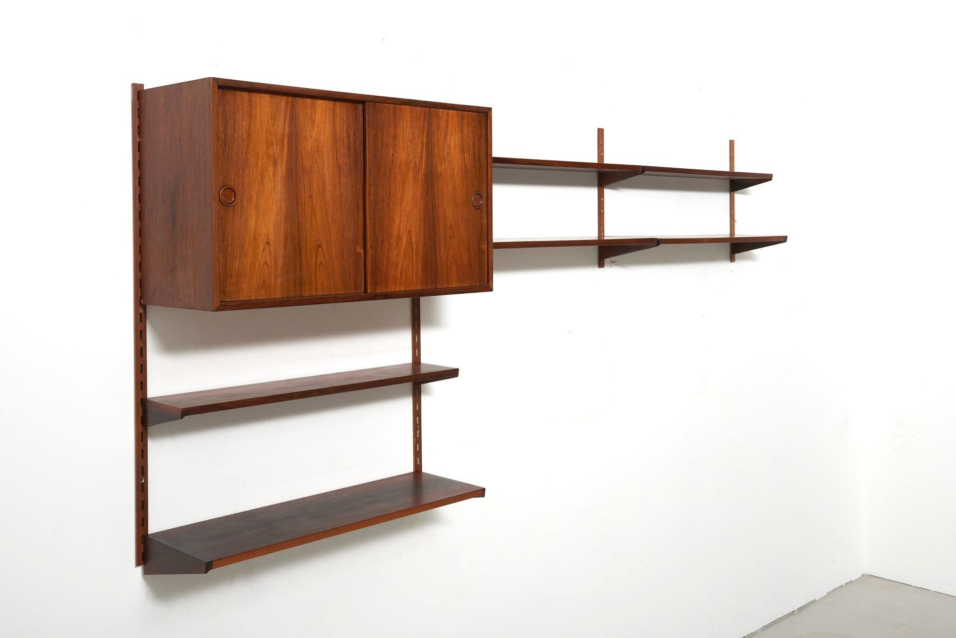 A wall unit in rosewood consisting 1 cabinet and 6 shelves. Design by Kai Kristiansen in circa 1960. Made by FM (Feldballes Møbelfabrik) in Denmark.
 