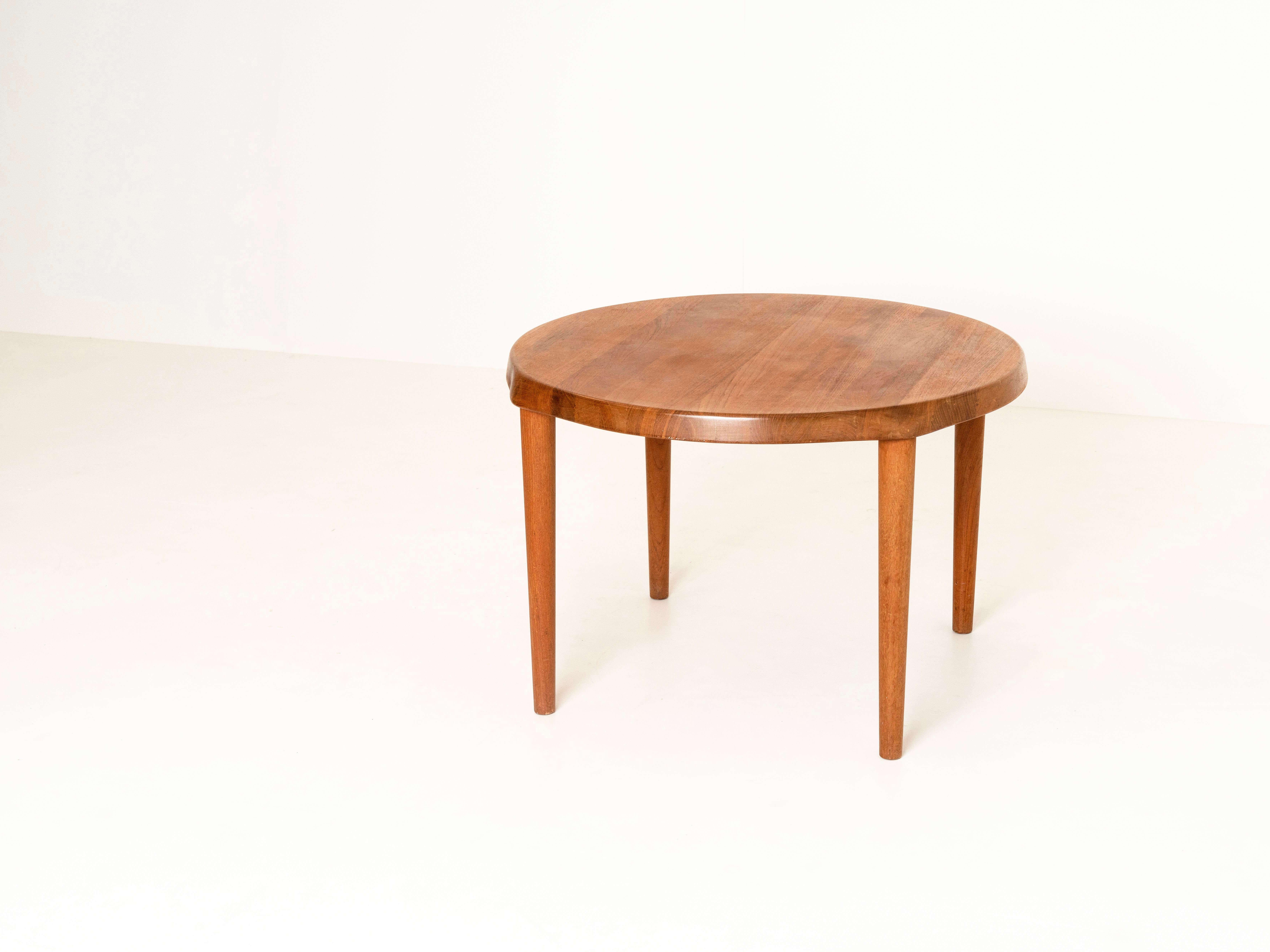Robust teak round coffee table by John Boné for Mikael Laursen from Denmark, the 1960s. This table is quite heavy and has a top that is 5 cm thick. The legs have a slight coned shape and the top has a nice detail above each leg. The table is in very