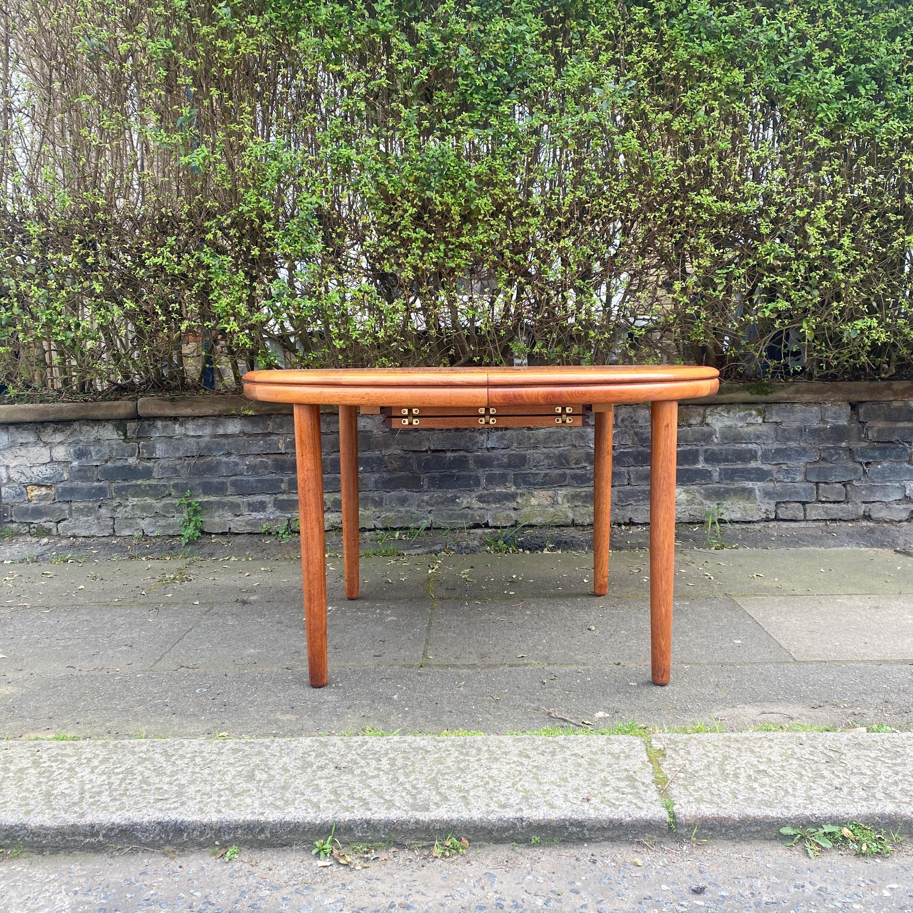 Add elegance and versatility to your dining space with this White & Newton Teak Round Extending Double Lip Dining Table. Crafted with high-quality teak wood by renowned British furniture maker White & Newton, this table boasts both style and