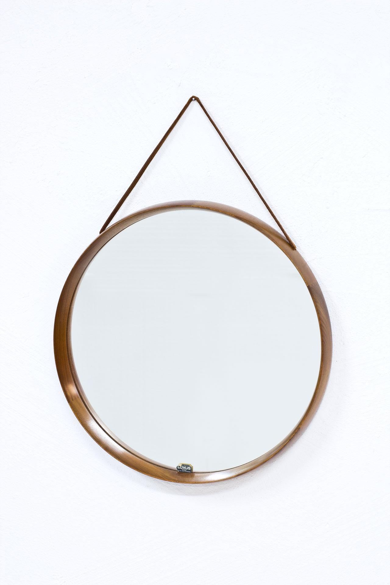 Teak round wall mirror designed by Uno & Östen Kristiansson for their own company Luxus at Vittsjö, Sweden during the 1950s. Made from teak with leather strap. Labeled.
 