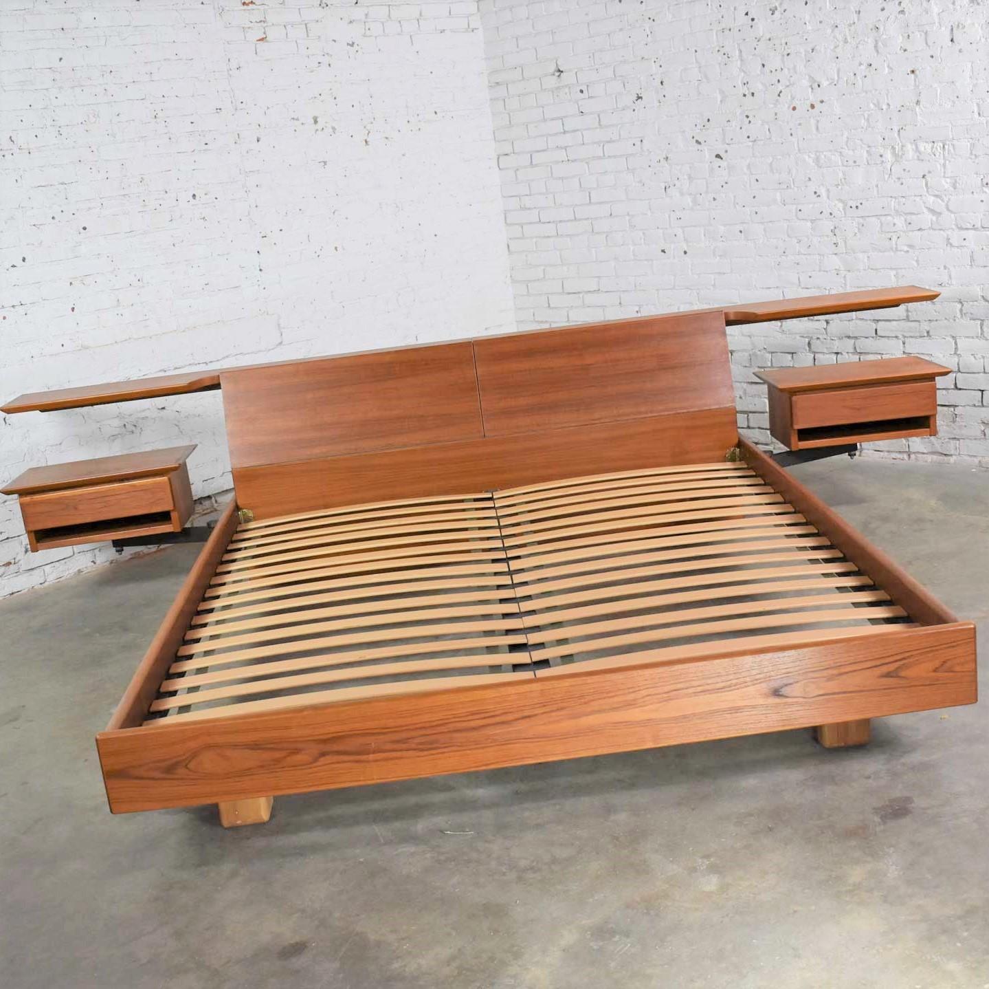 Handsome California king size Scandinavian Modern teak platform bed with flip out storage headboard and mounted swing-arm nightstands, by Dyrlund. It is in fabulous vintage condition apart from a hint of a water ring on one of the nightstand tops.