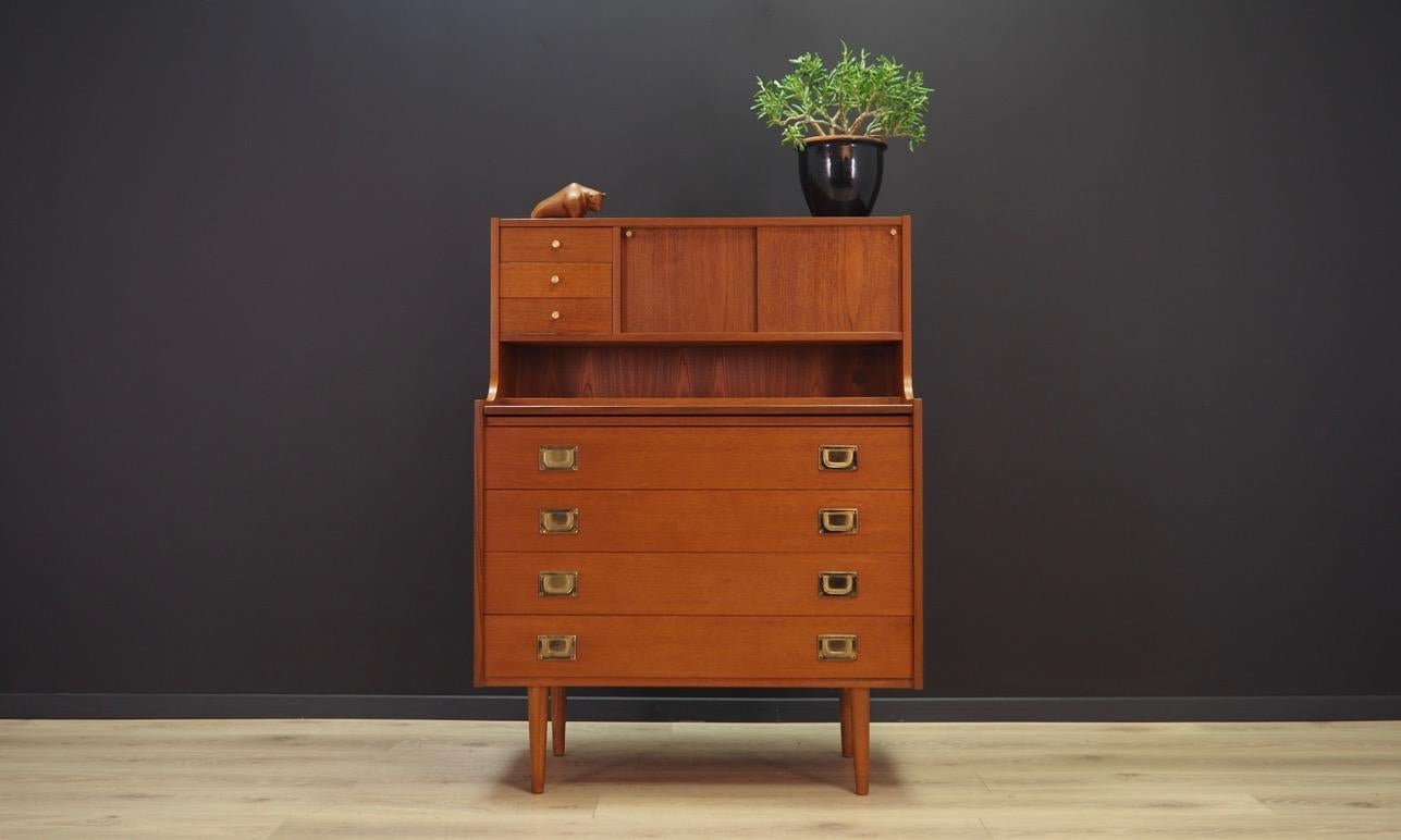 The phenomenal 1960s-1970s secretary. Scandinavian design, Minimalist form. Furniture finished with teak veneer. The secretary has four drawers and a mirror behind a sliding door. An additional advantage is a pull-out top. Maintained in good