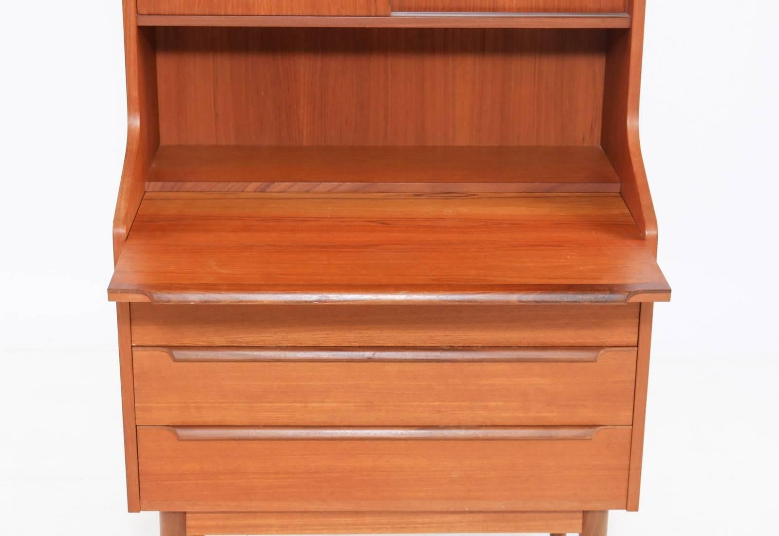 Library / teak secretary from a Danish designer. Teak shelf plywood, front with three drawers, doors behind which shelves and extractable writing shutters. H. 163 cm. B. 80 cm. D. 46 cm. Traces of wear, including scratches / marks and colour