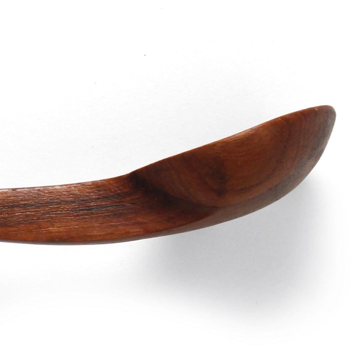 A pair of hand-carved teak serving spoons with curved elongated handles.