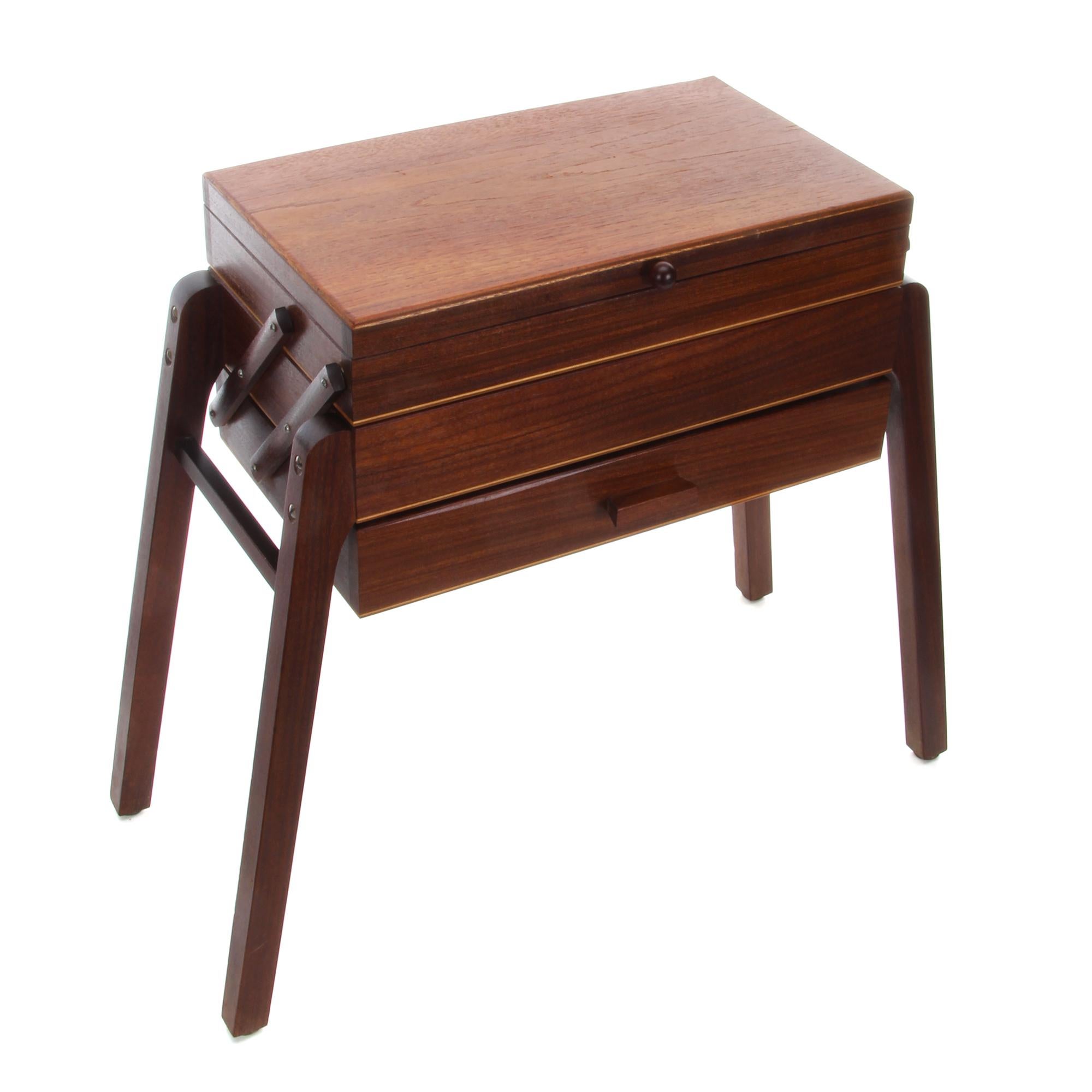 Teak sewing table, 1960s - elegant Danish modern folding sewing cabinet with three drawers, in good vintage condition.

A charming midcentury teak sewing table with a compact body and three drawers in front, carried by four teak legs slightly